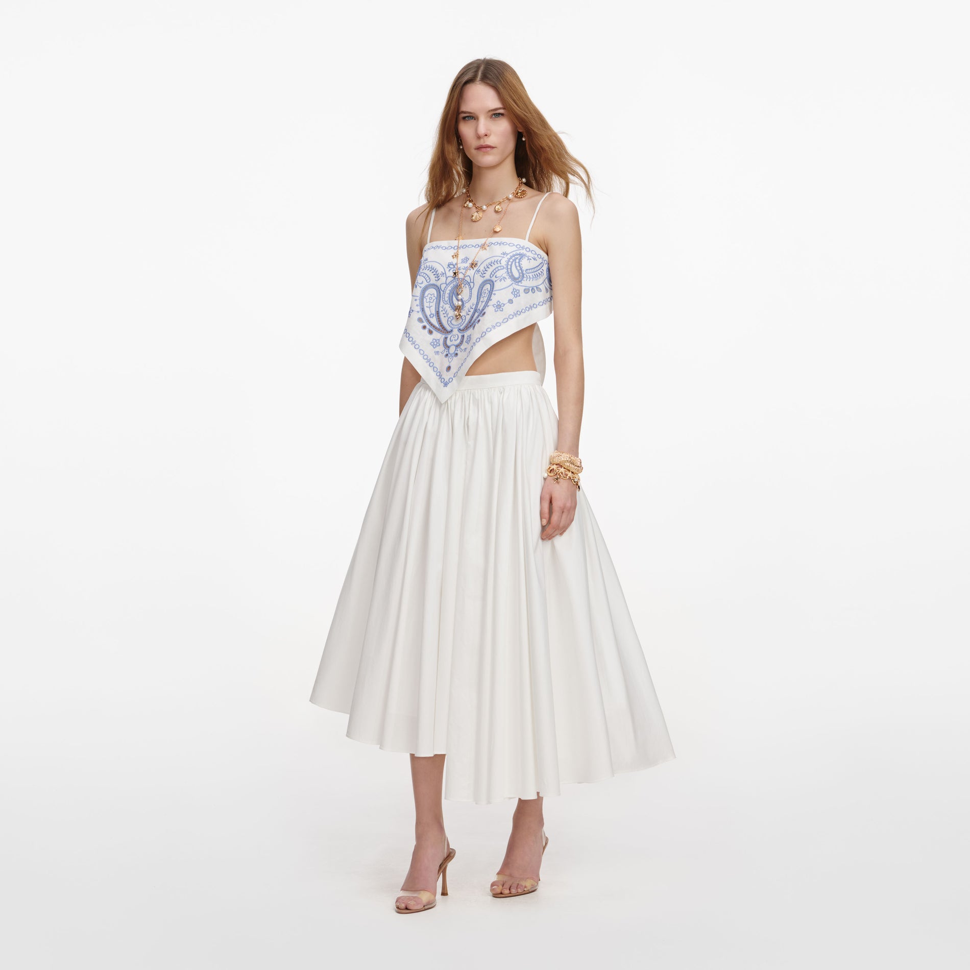 Side view of a woman wearing the White And Blue Embroidered Linen Top