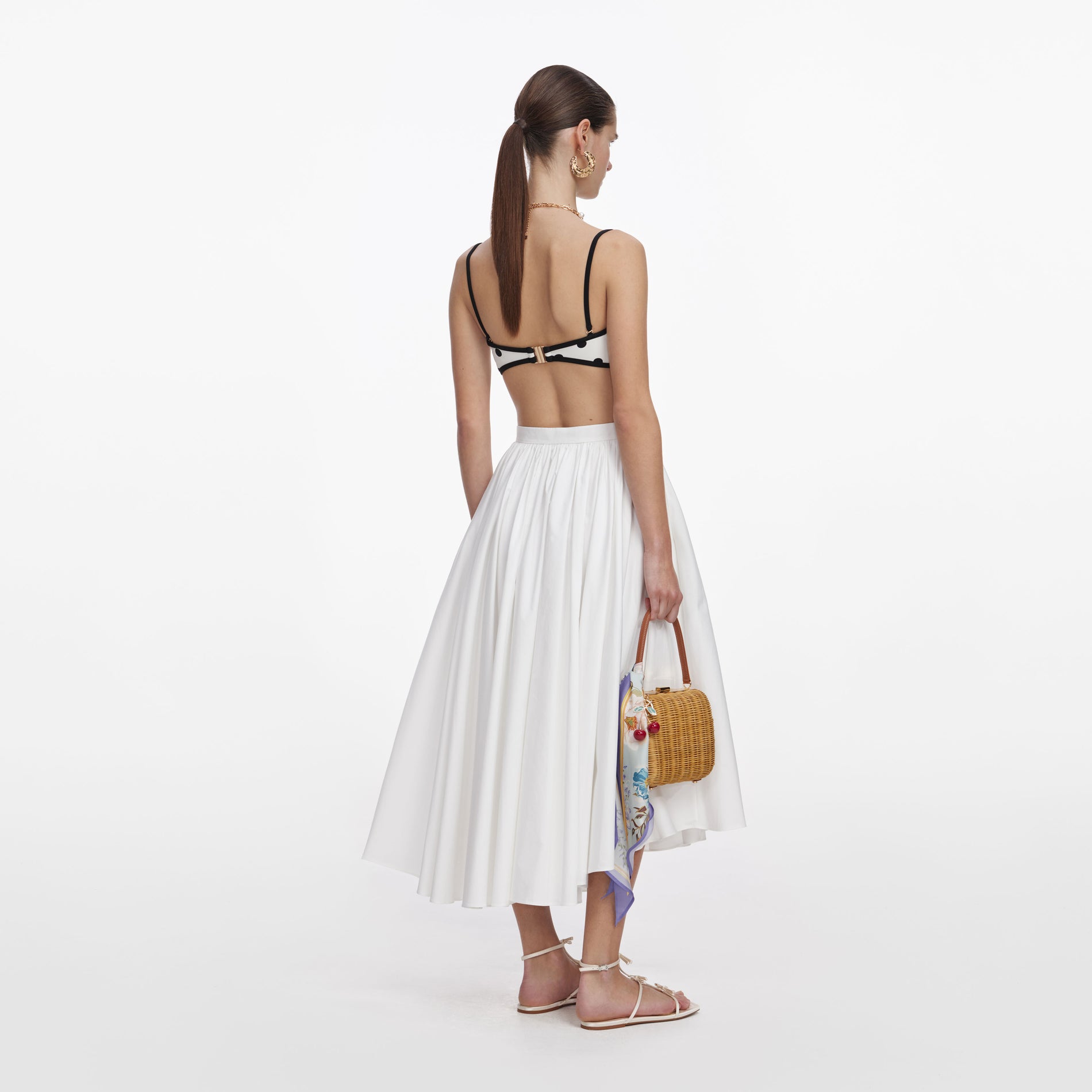 Back view of a woman wearing the White Polka Dot Bikini Top