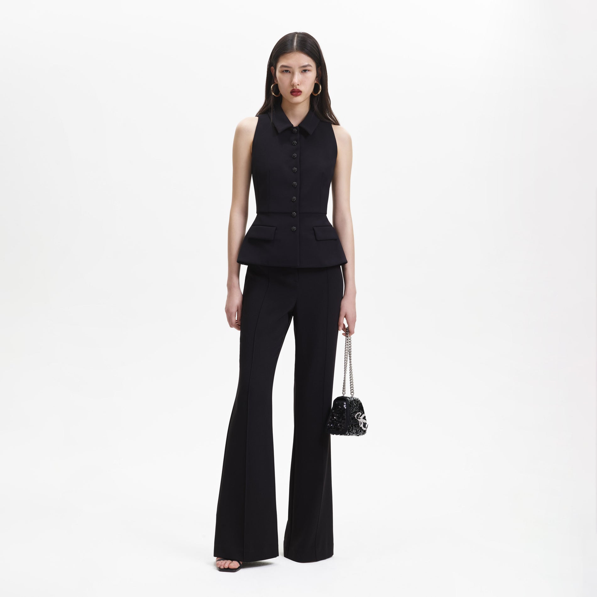 A woman wearing the Black Tailored Jumpsuit