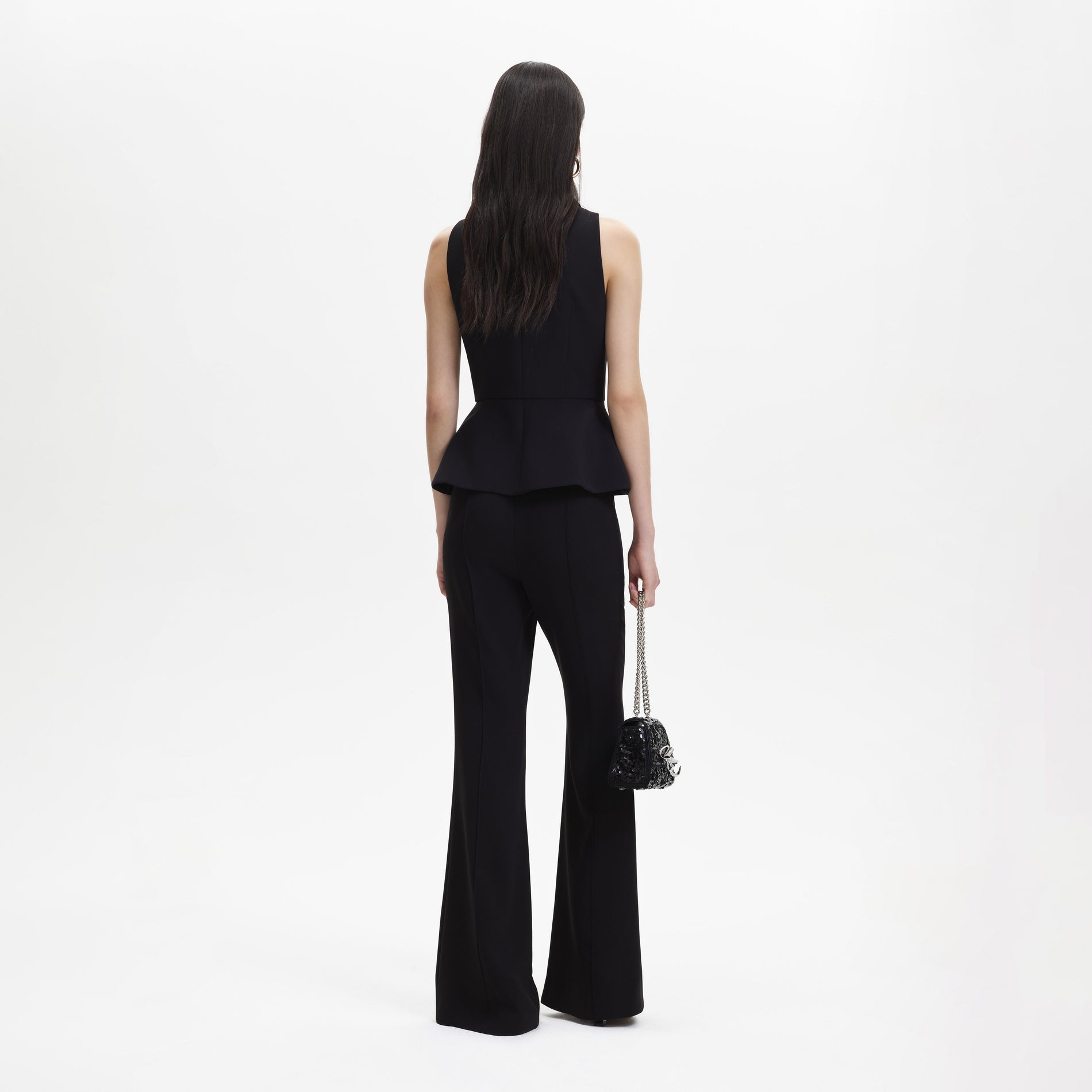 A woman wearing the Black Tailored Jumpsuit