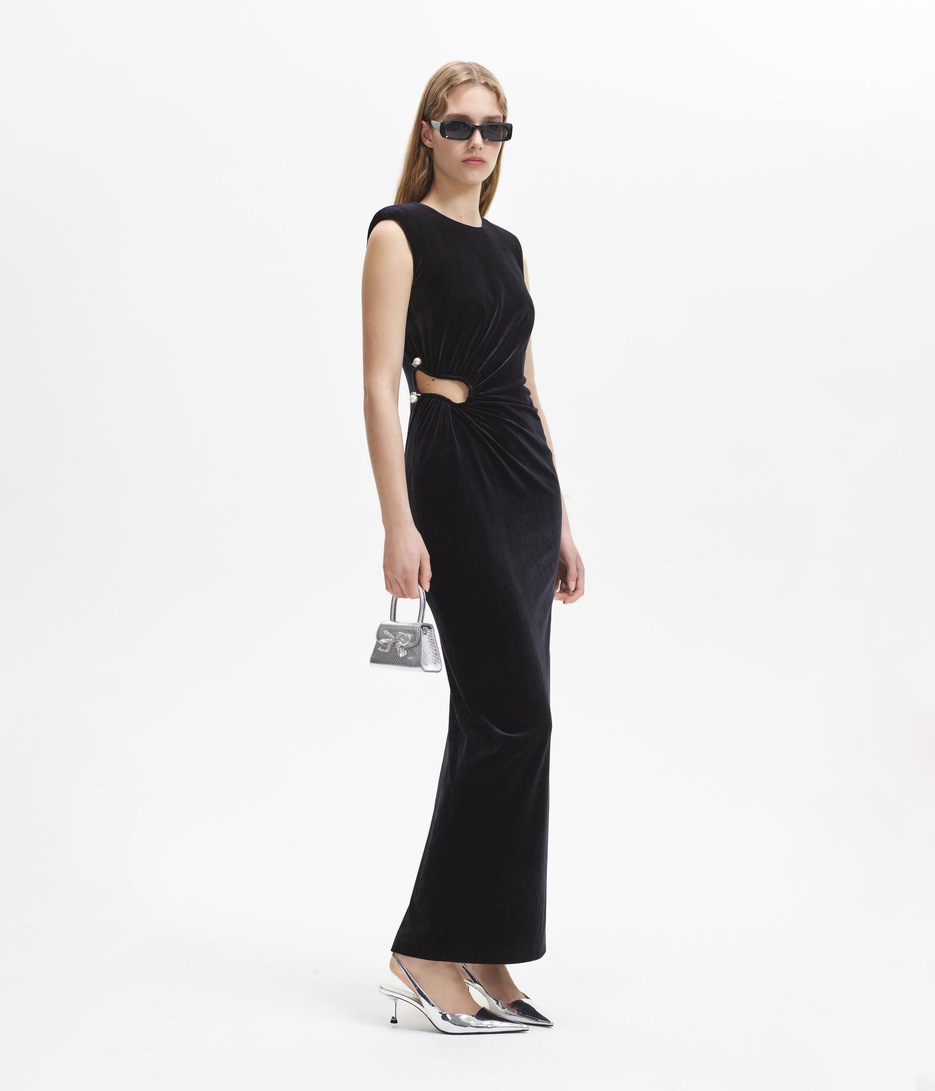 Side view of a woman wearing the Black Velvet Cut Out Maxi Dress