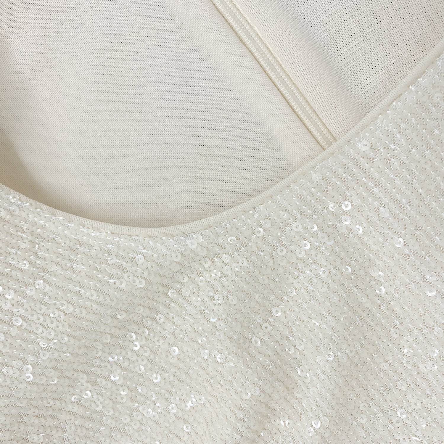 A close up of the fabric for the Cream Sequin Feather Top