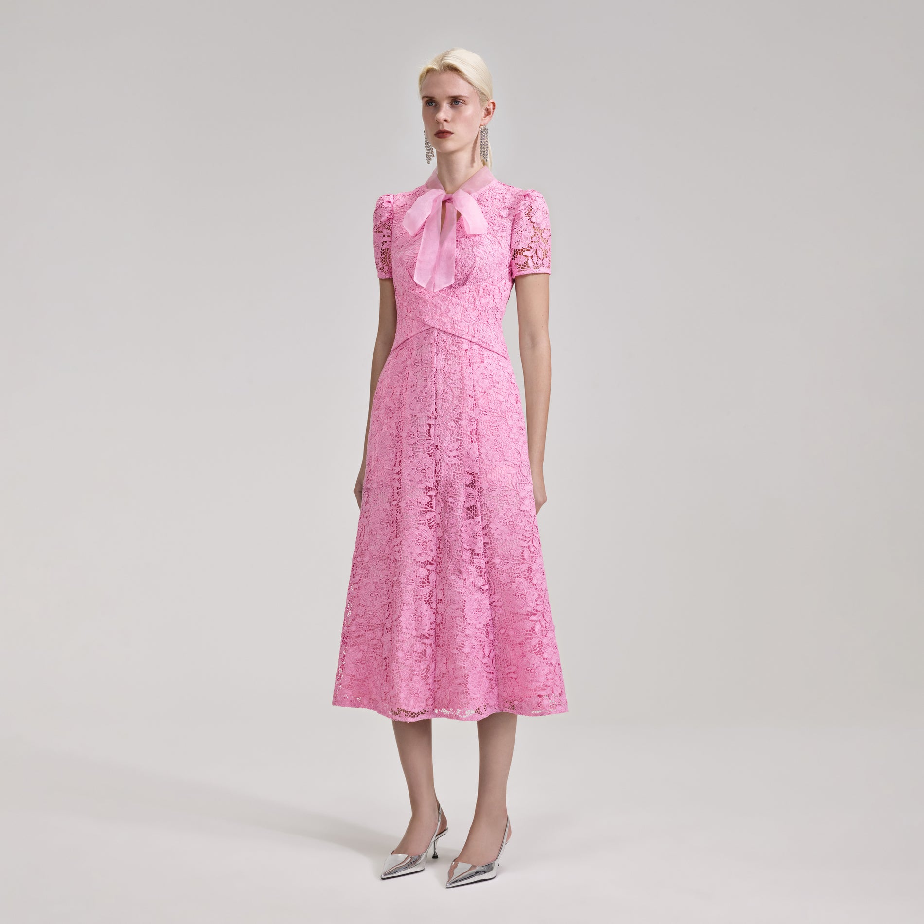 A woman wearing the Pink Cord Lace Crossover Midi Dress