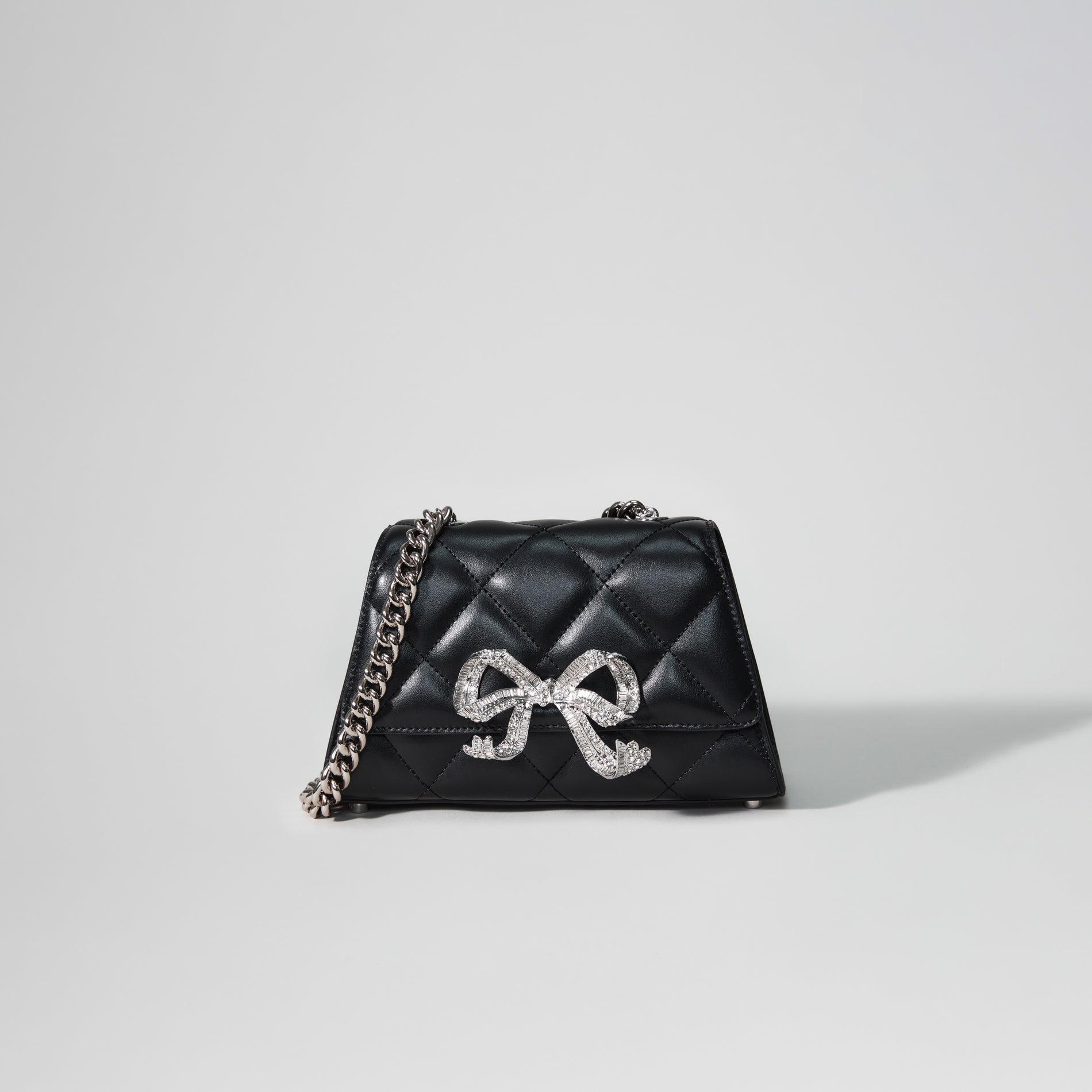 A woman wearing the Black Quilted Shoulder Mini Bow Bag