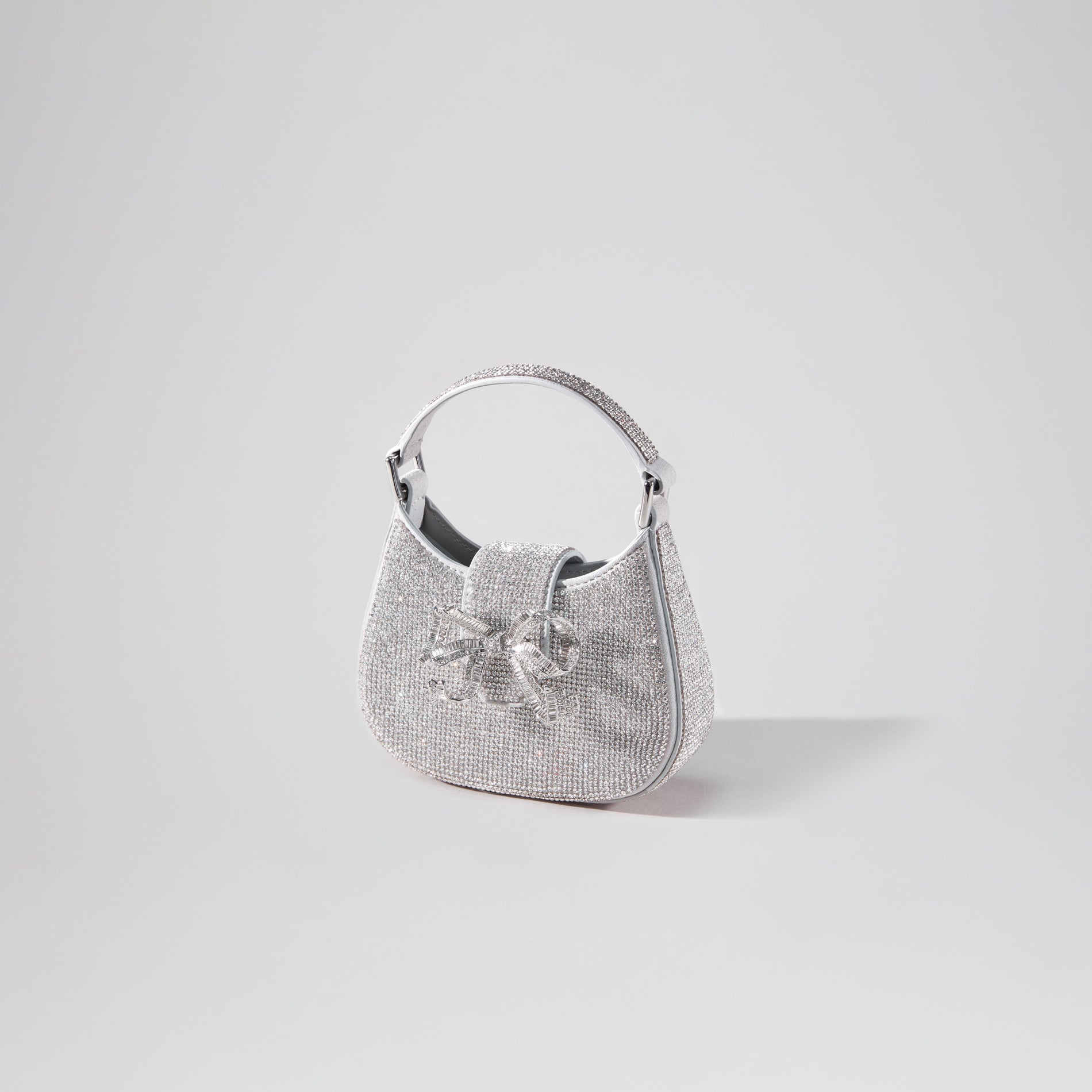 Side view of a woman wearing the Silver Rhinestone Crescent Bow Micro Bag