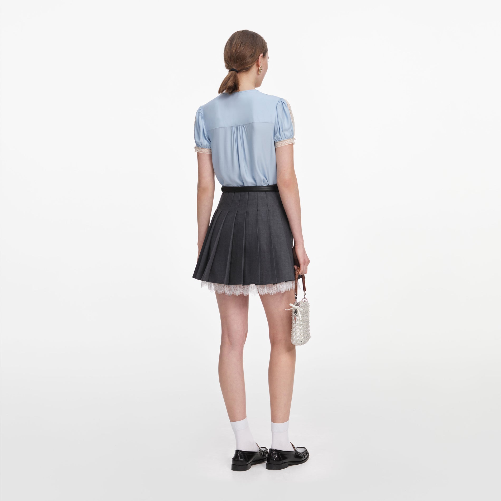 Back view of a woman wearing the Grey Pleated Mini Skirt