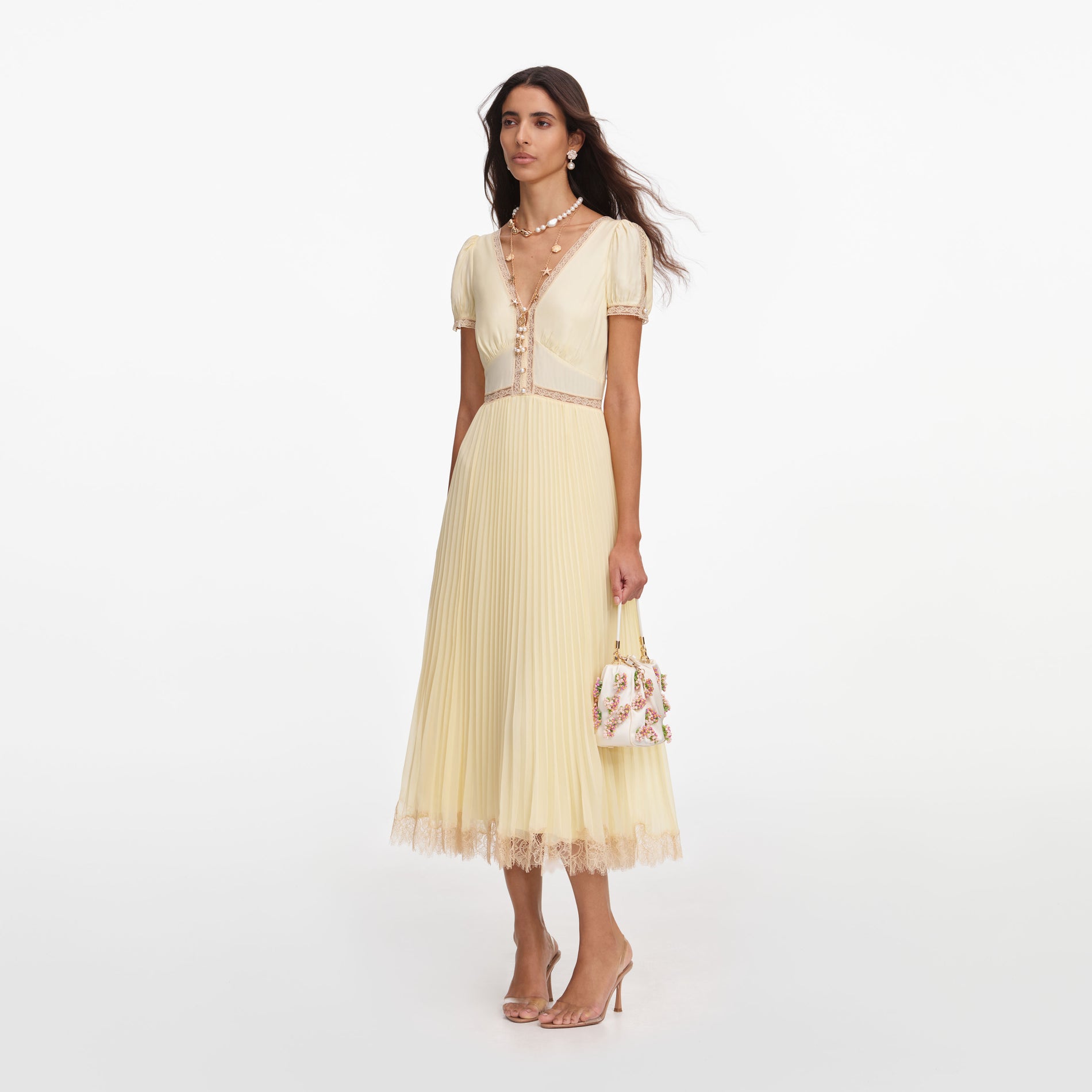 Side view of a woman wearing the Yellow Viscose Pleated Lace Midi Dress