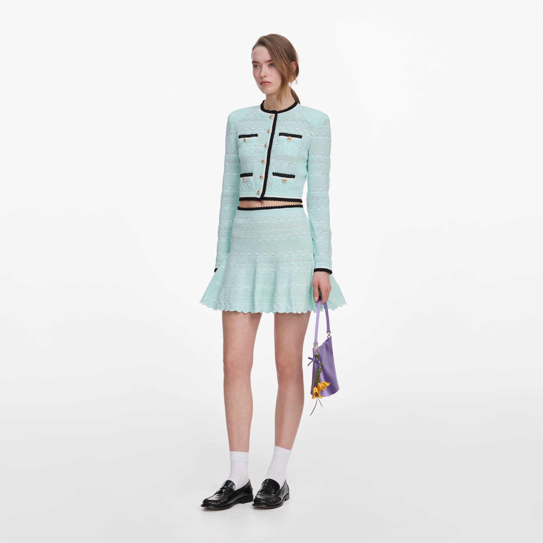 Side view of a woman wearing the Mint Pointelle Knit Mini Skirt