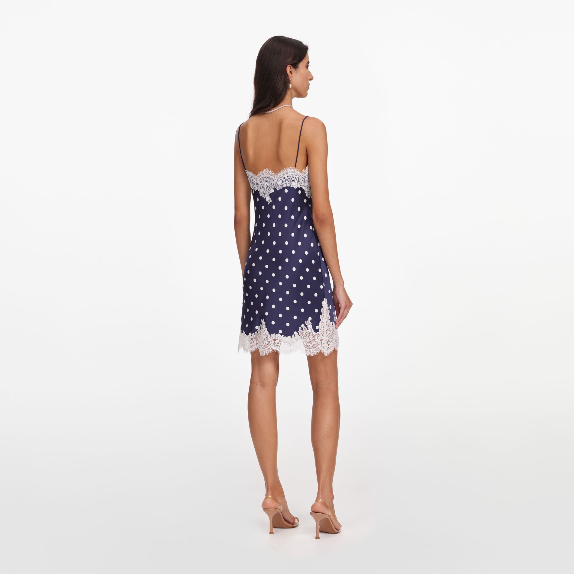 Back view of a woman wearing the Navy Polka Dot Satin Mini Dress