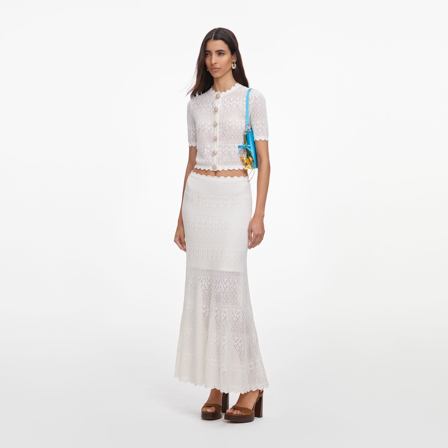 Side view of a woman wearing the White Pointelle Knit Midi Skirt