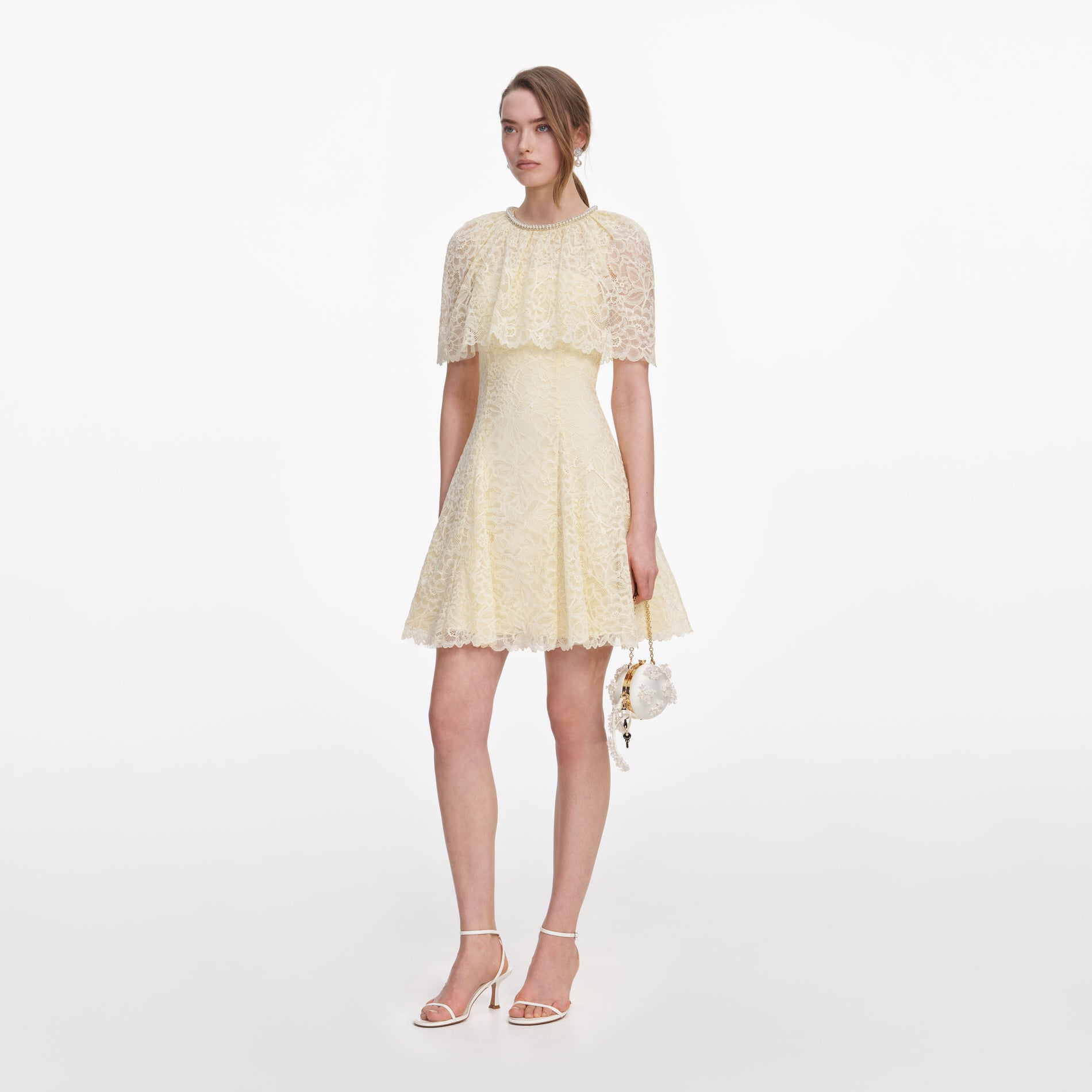 Side view of a woman wearing the Yellow Lace Cape Mini Dress