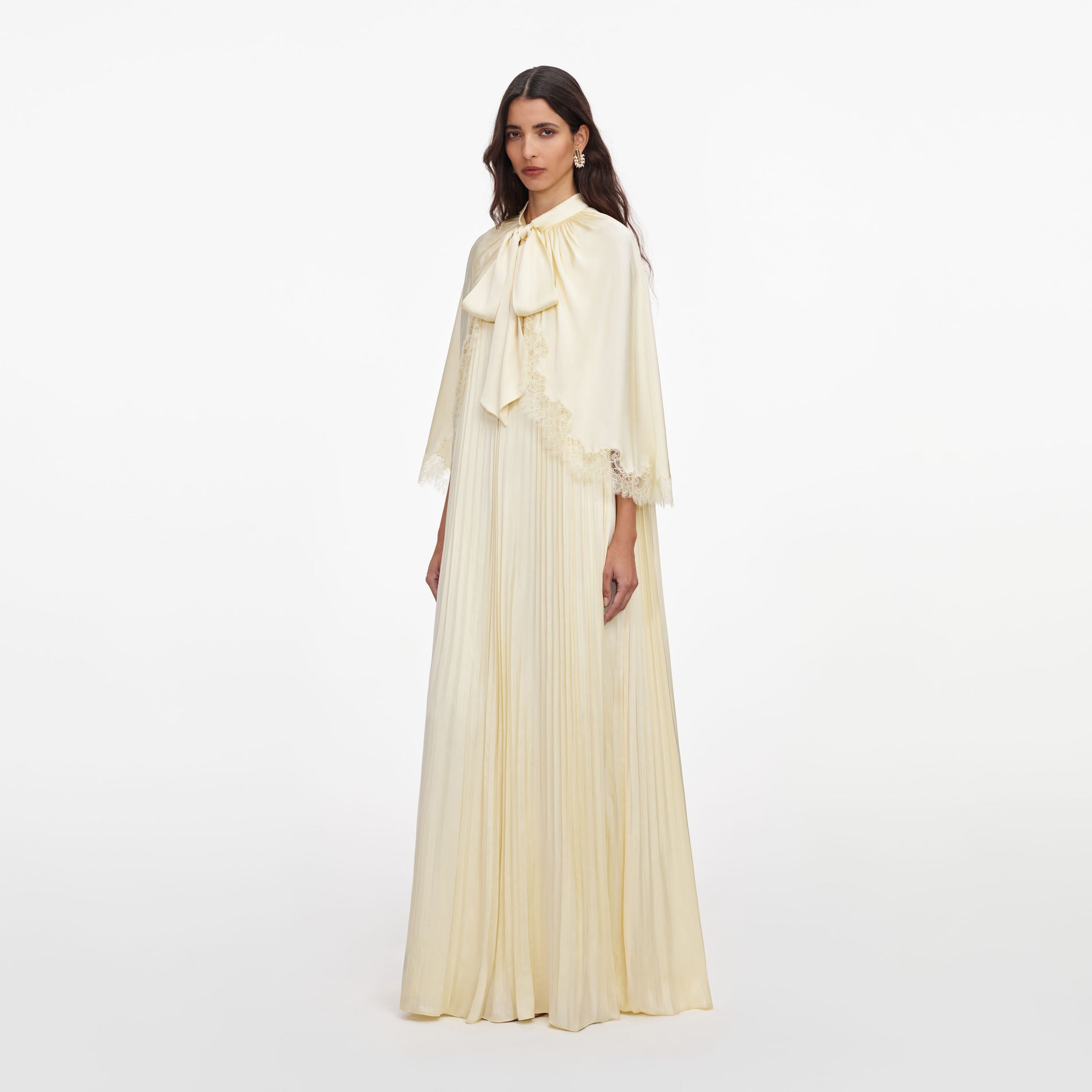 Side view of a woman wearing the Yellow Tie Neck Cape Maxi Dress