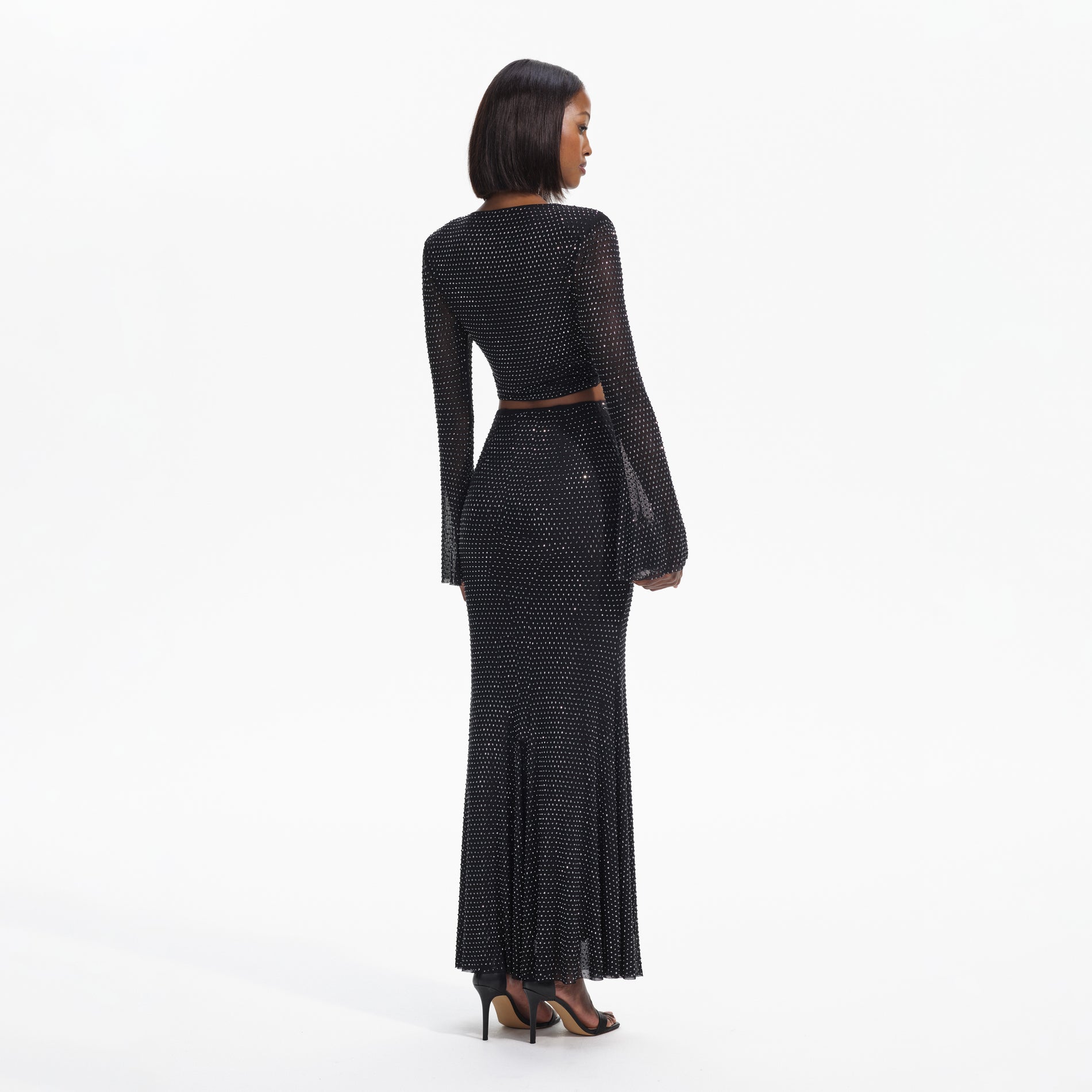Back view of a woman wearing the Black Rhinestone Maxi Skirt