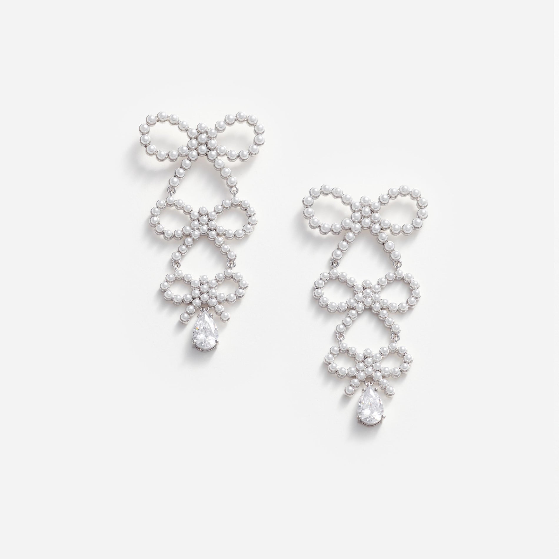 Front view of a woman wearing the Tiered Pearl Bow Earrings