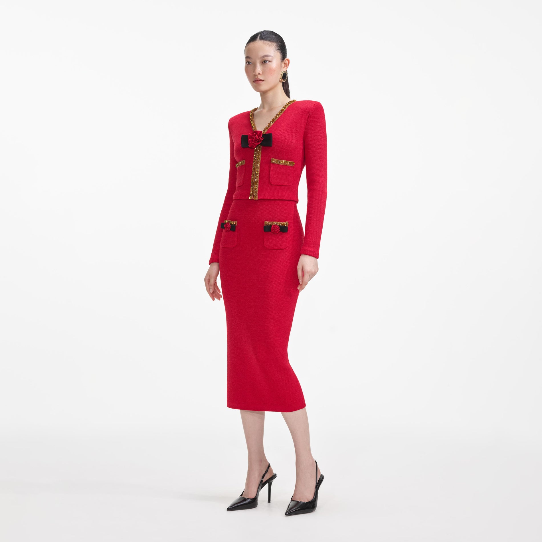 Side view of a woman wearing the Red Textured Knit Corsage Midi Skirt