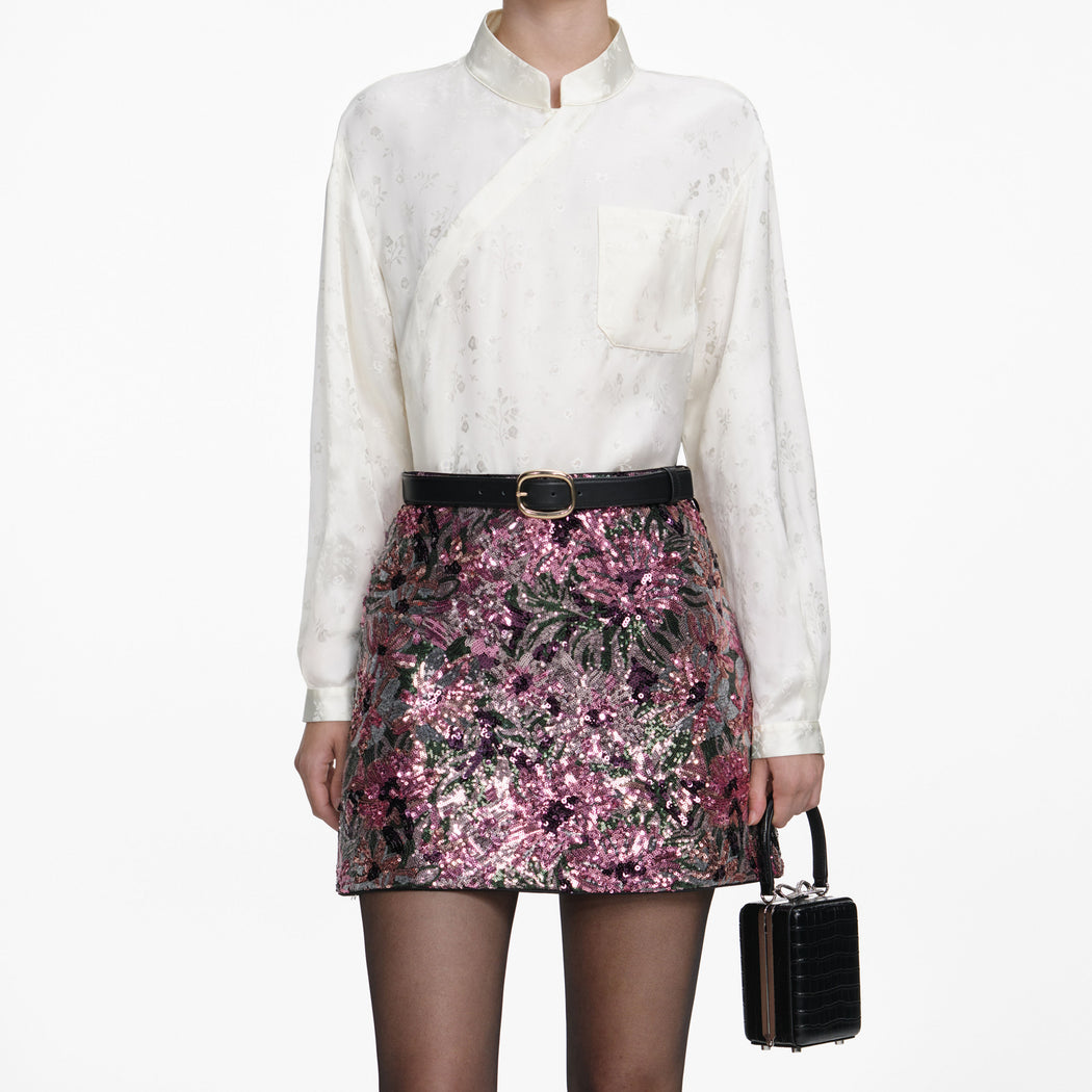 A close up of a woman wearing the Floral Sequin Mini Skirt