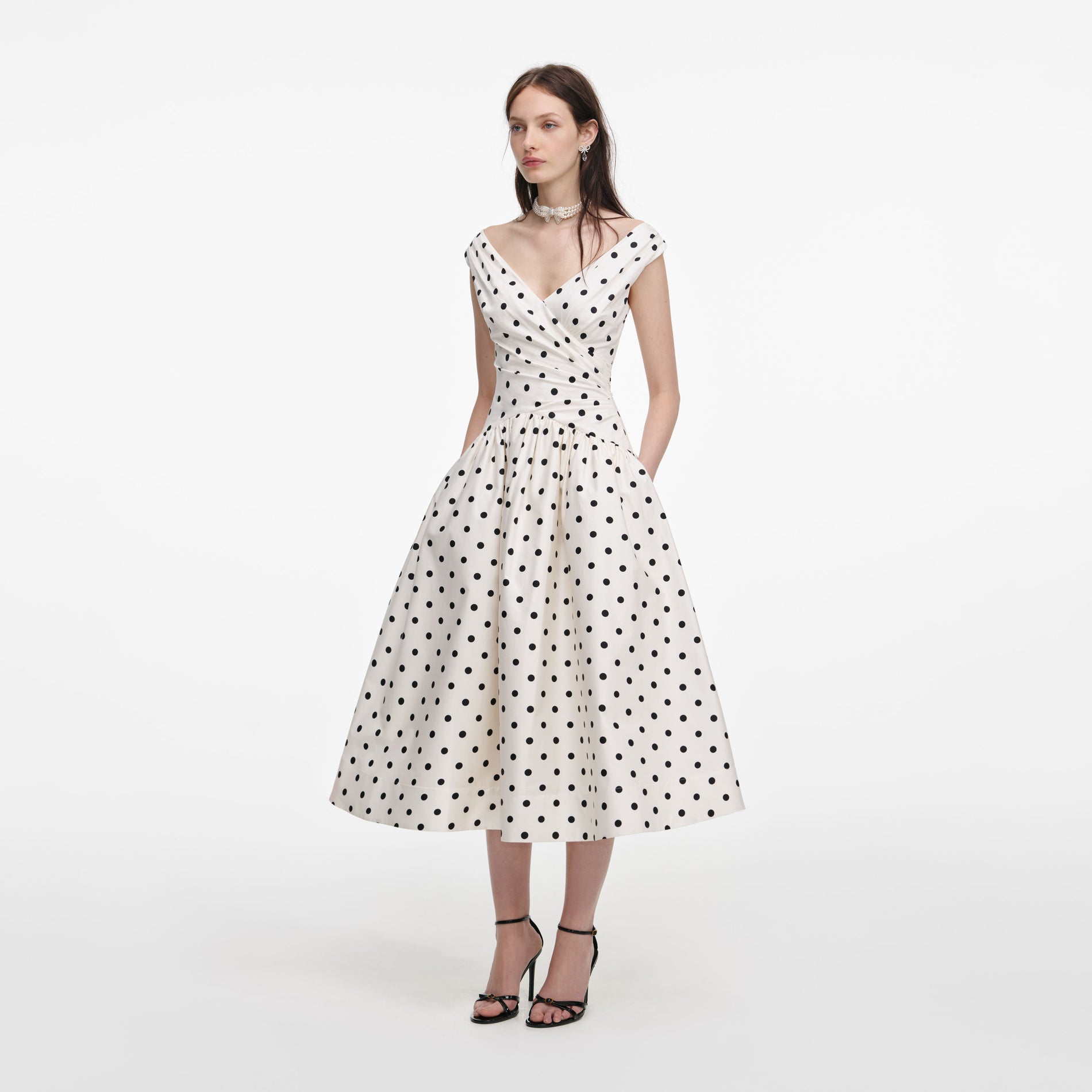 Side view of a woman wearing the Cream Polka Dot Cotton Midi Dress