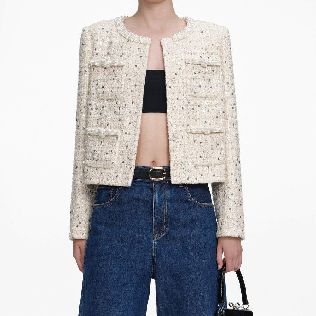 A close up of a woman wearing the Cream Embellished Boucle Jacket