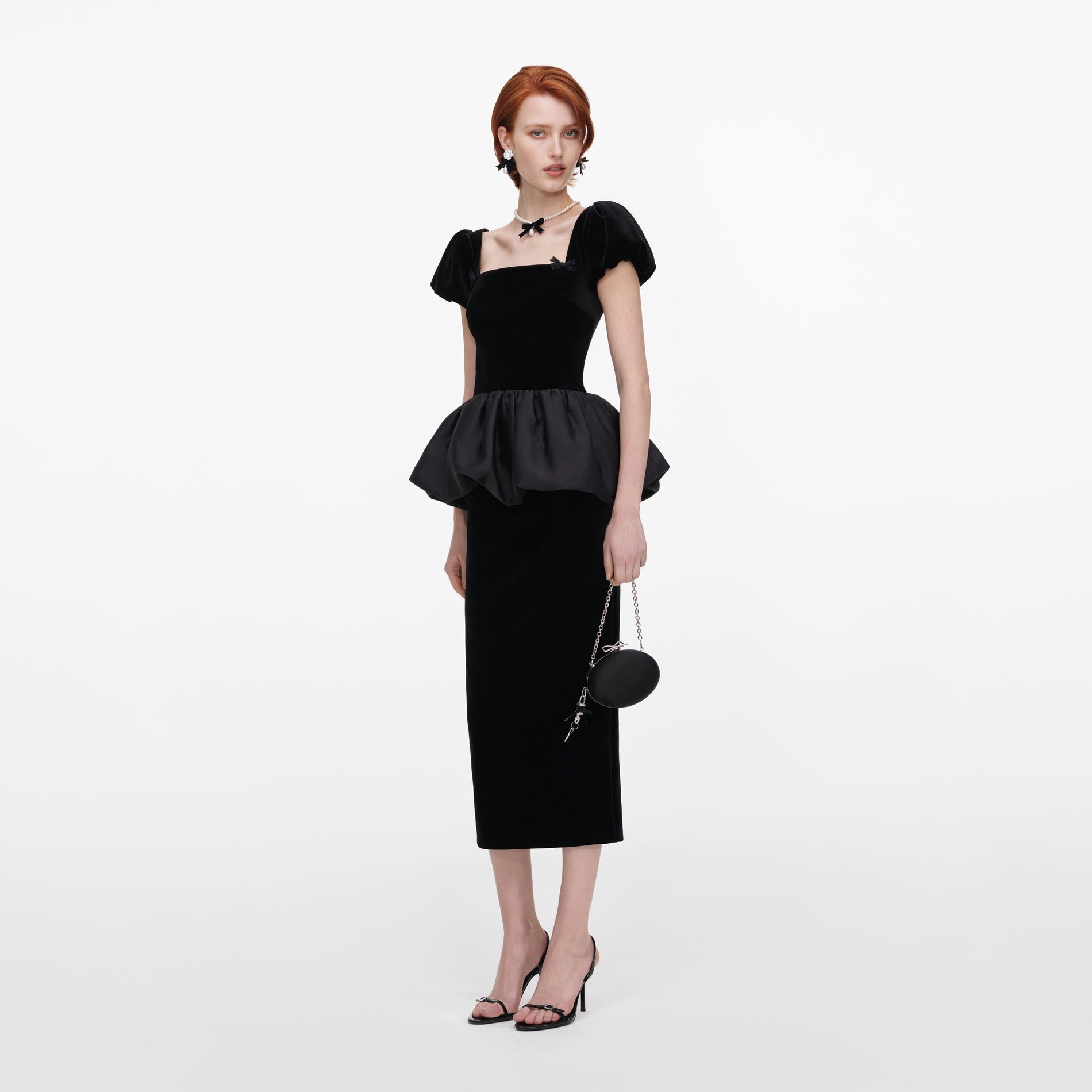 Side view of a woman wearing the Black Velvet Bubble Peplum Midi Dress