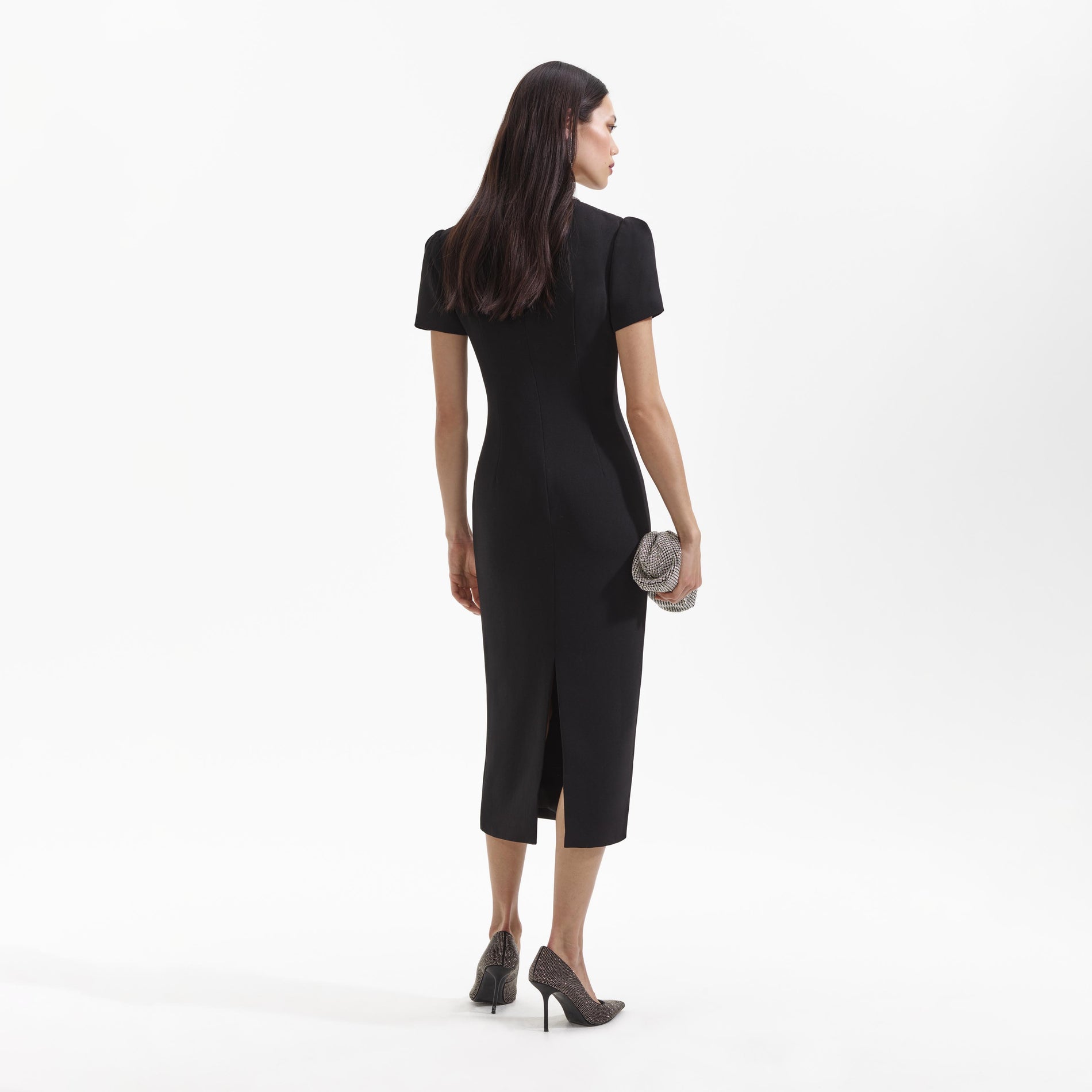 Back view of a woman wearing the Black Crepe Diamante Bow Midi Dress