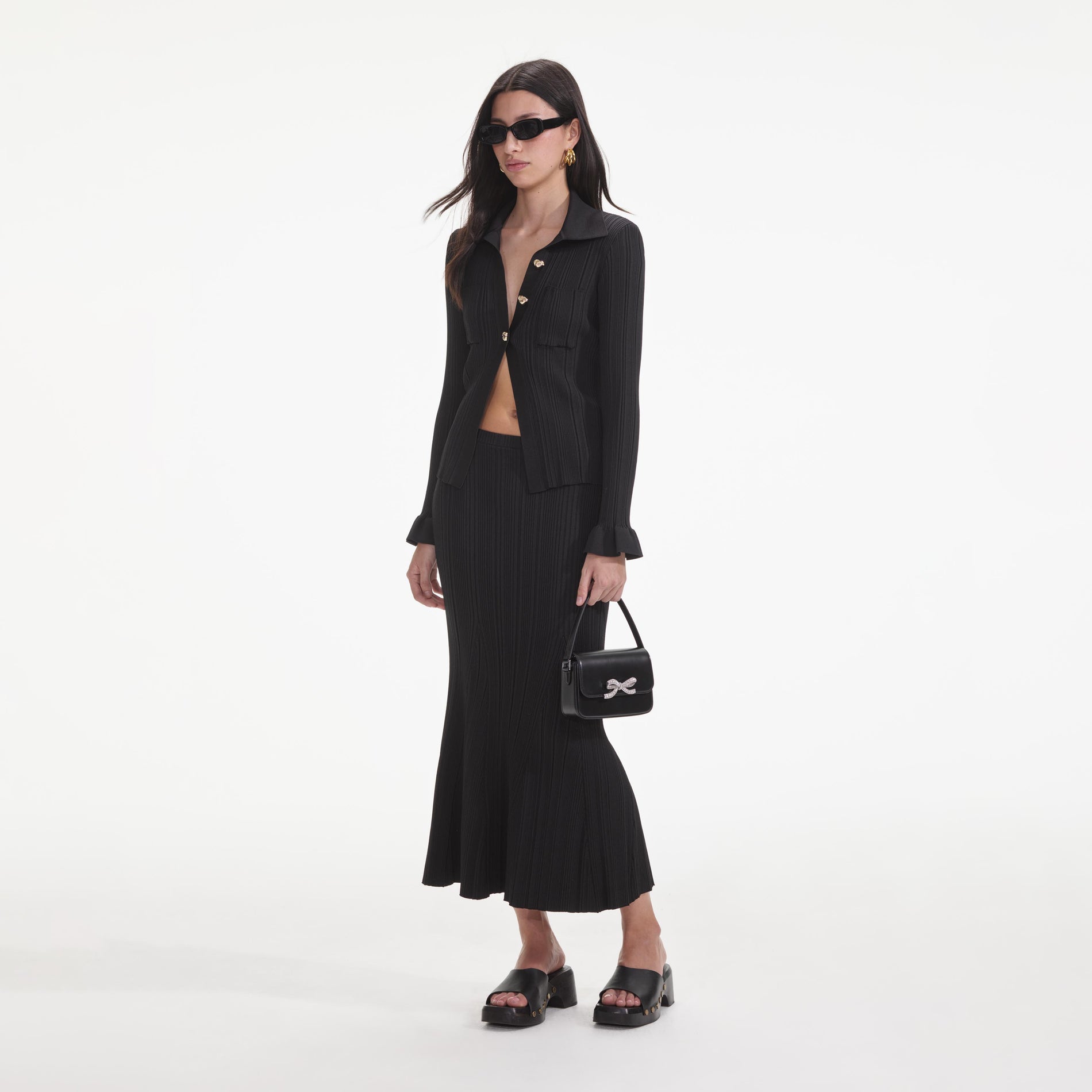 Side view of a woman wearing the Black Ribbed Midi Skirt