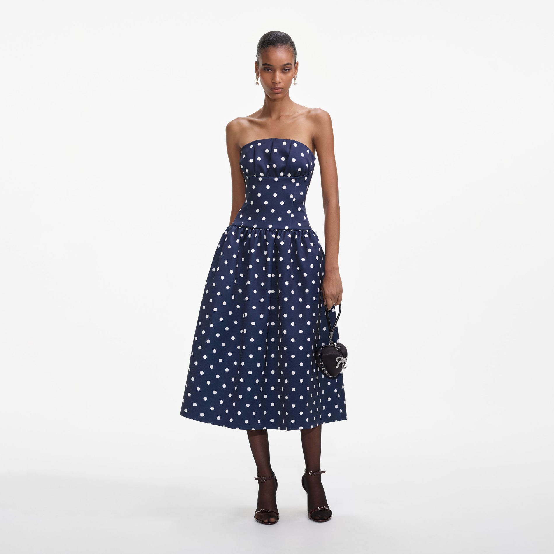 Front view of a woman wearing the Navy Polka Dot Satin Midi Dress