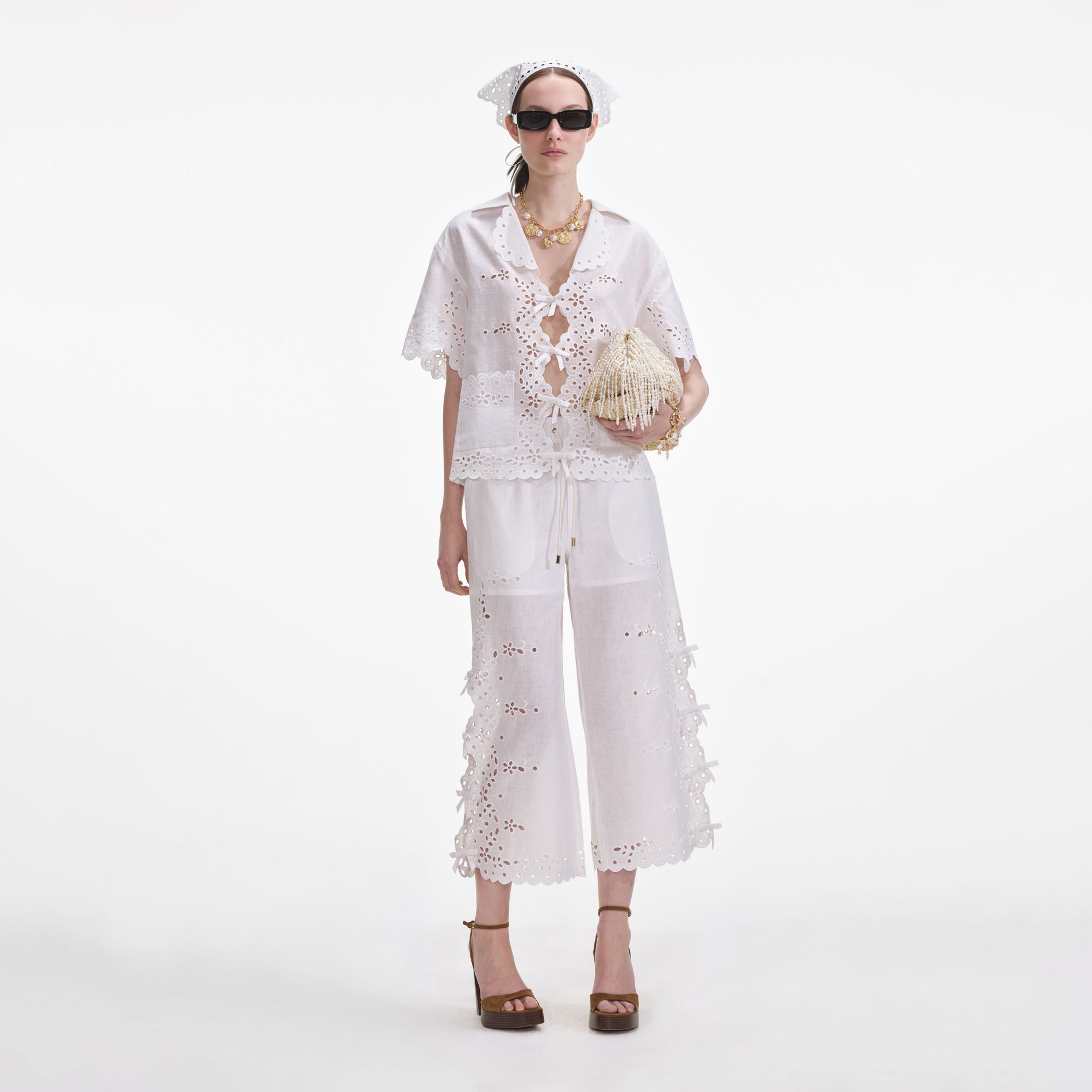 Front view of a woman wearing the Cream Linen Embroidered Trousers
