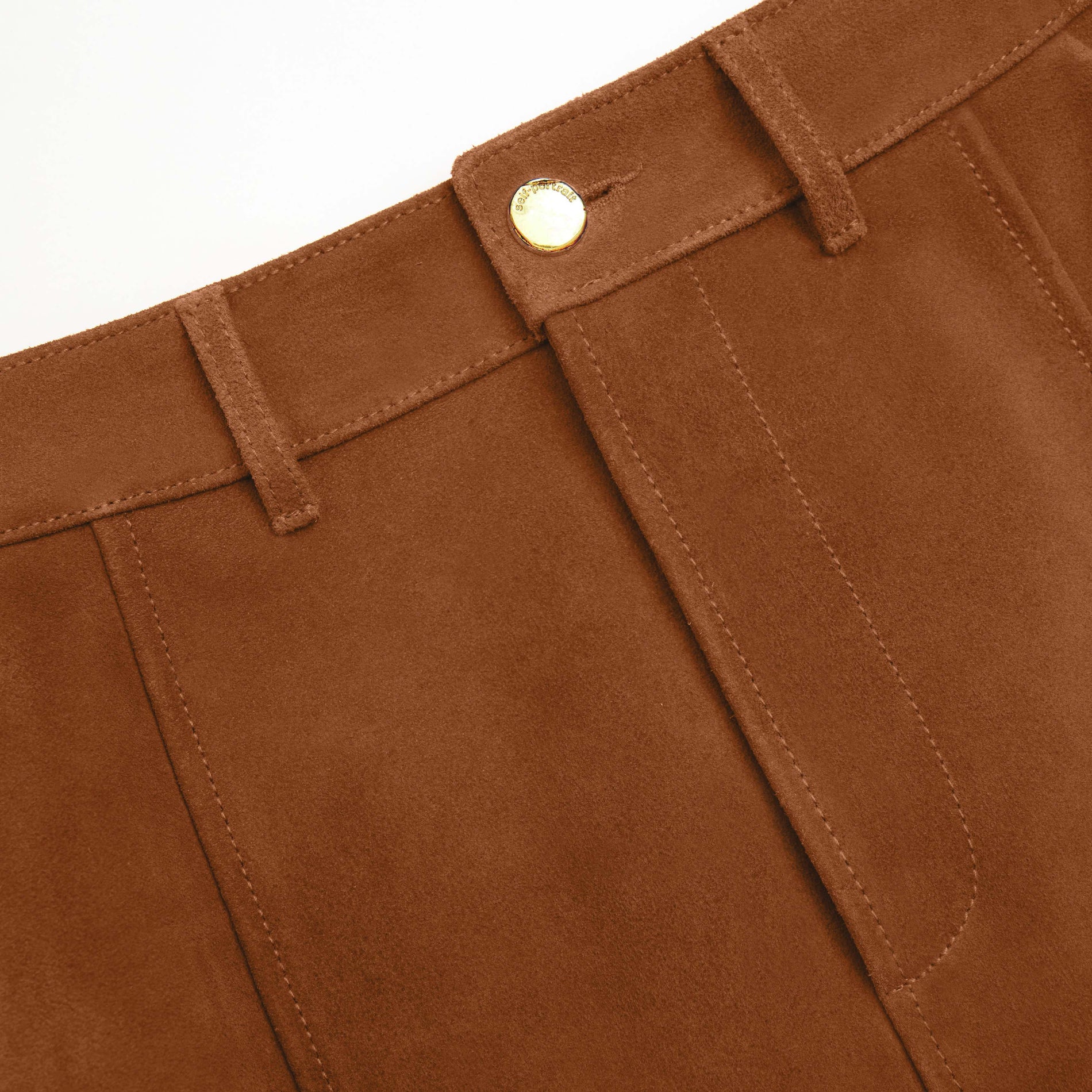 Side view of a woman wearing the Brown Suede Midi Skirt