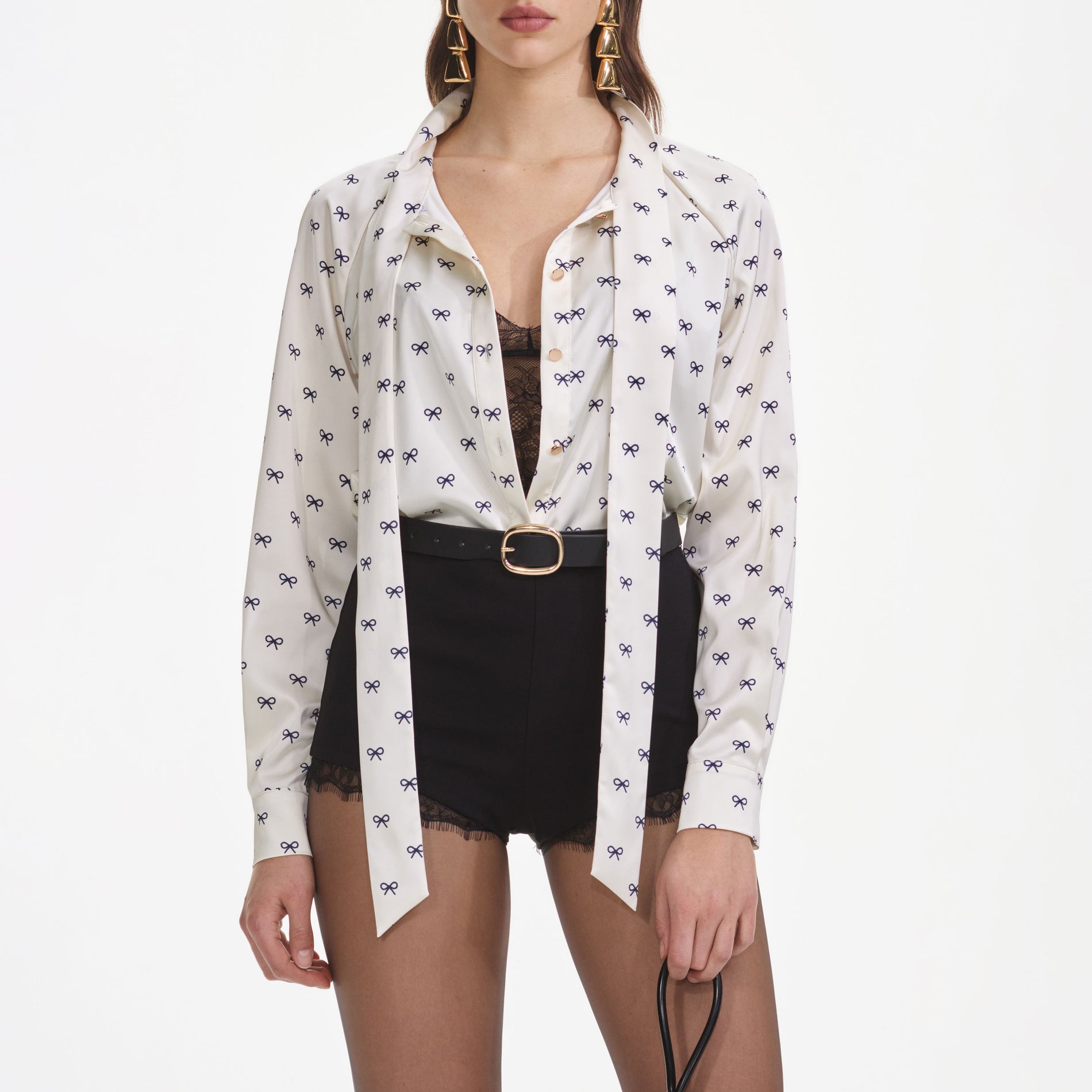 A close up of a woman wearing the Cream Satin Bow Print Blouse