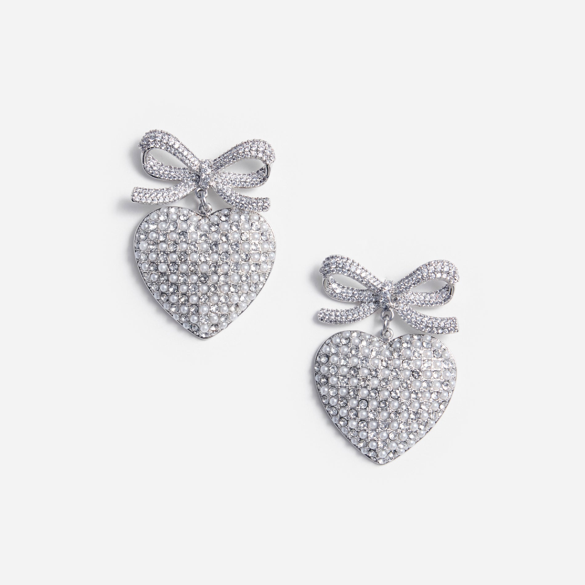 A photo of the Crystal Bow Pearl Heart Earrings