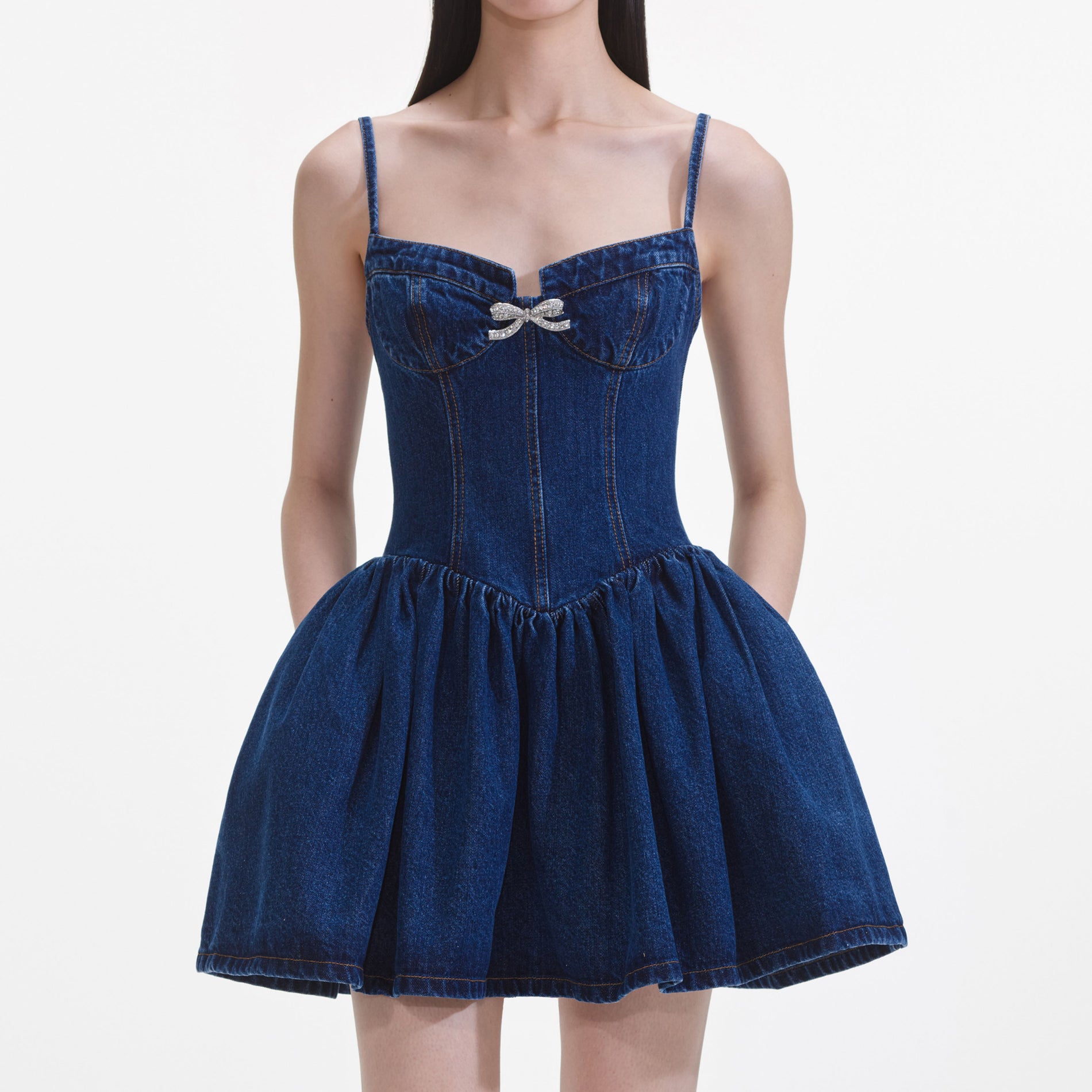 A close up of a woman wearing the Denim Diamante Bow Sweetheart Mini Dress