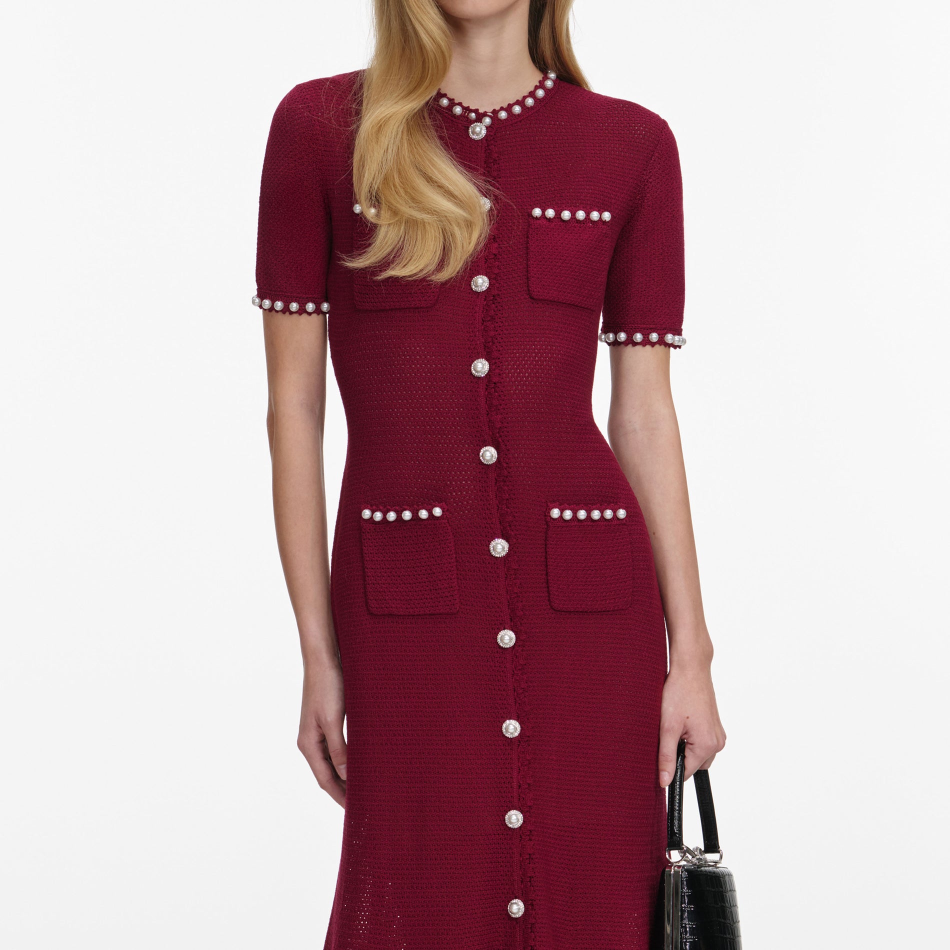 A close up of a woman wearing the Burgundy Pearl Knit Midi Dress