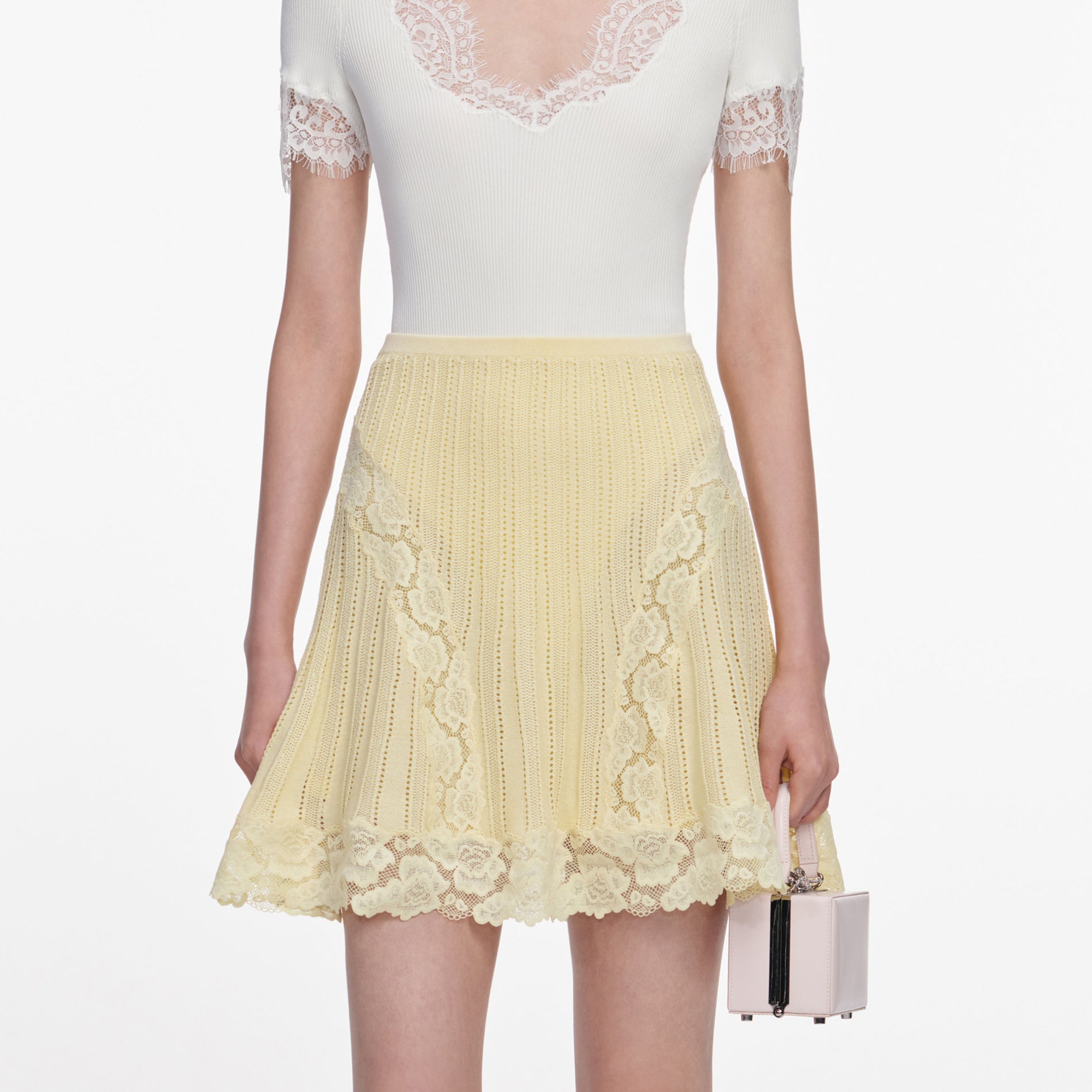 A close up of a woman wearing the Yellow Pointelle Knit Mini Skirt