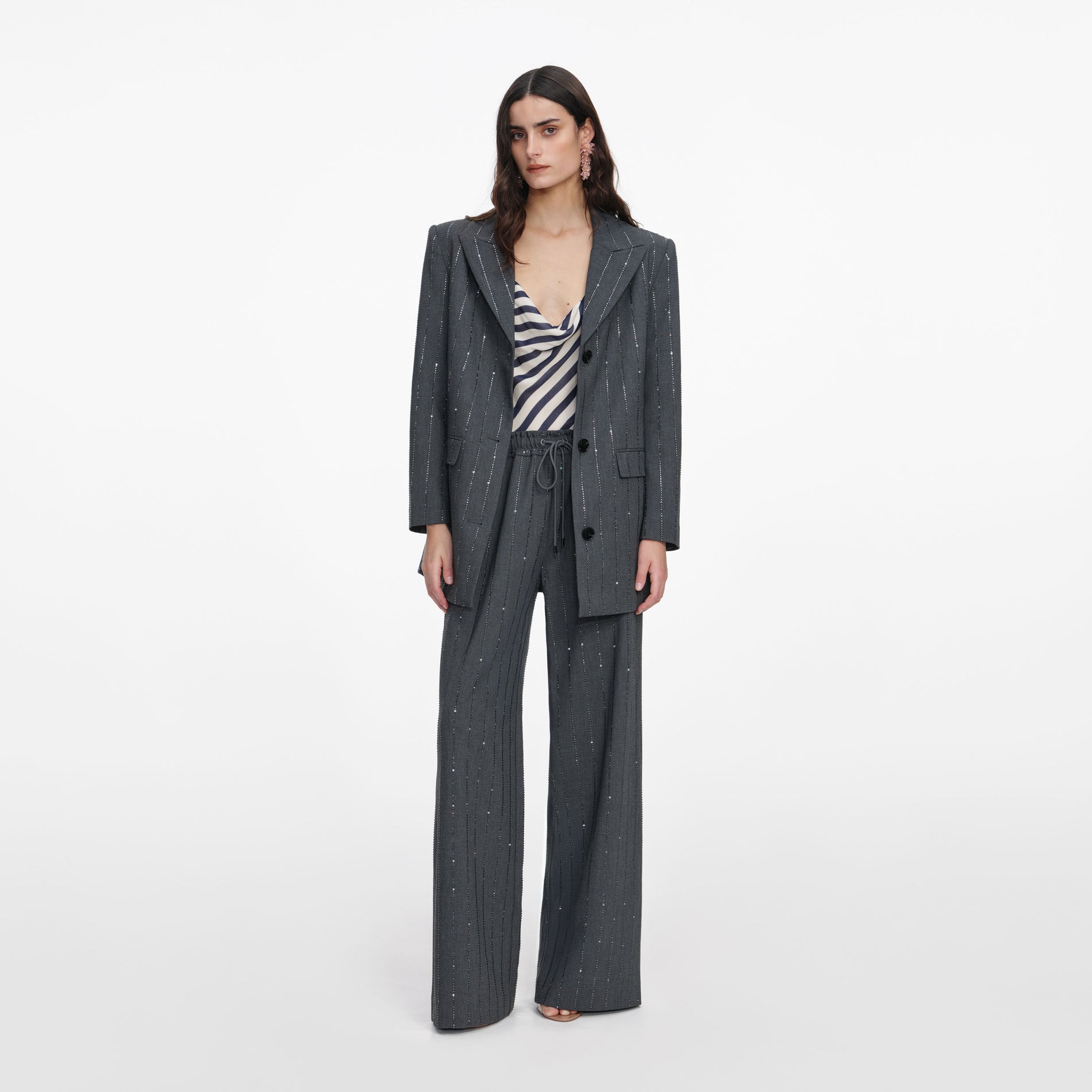A close up of a woman wearing the Grey Rhinestone Pinstripe Blazer