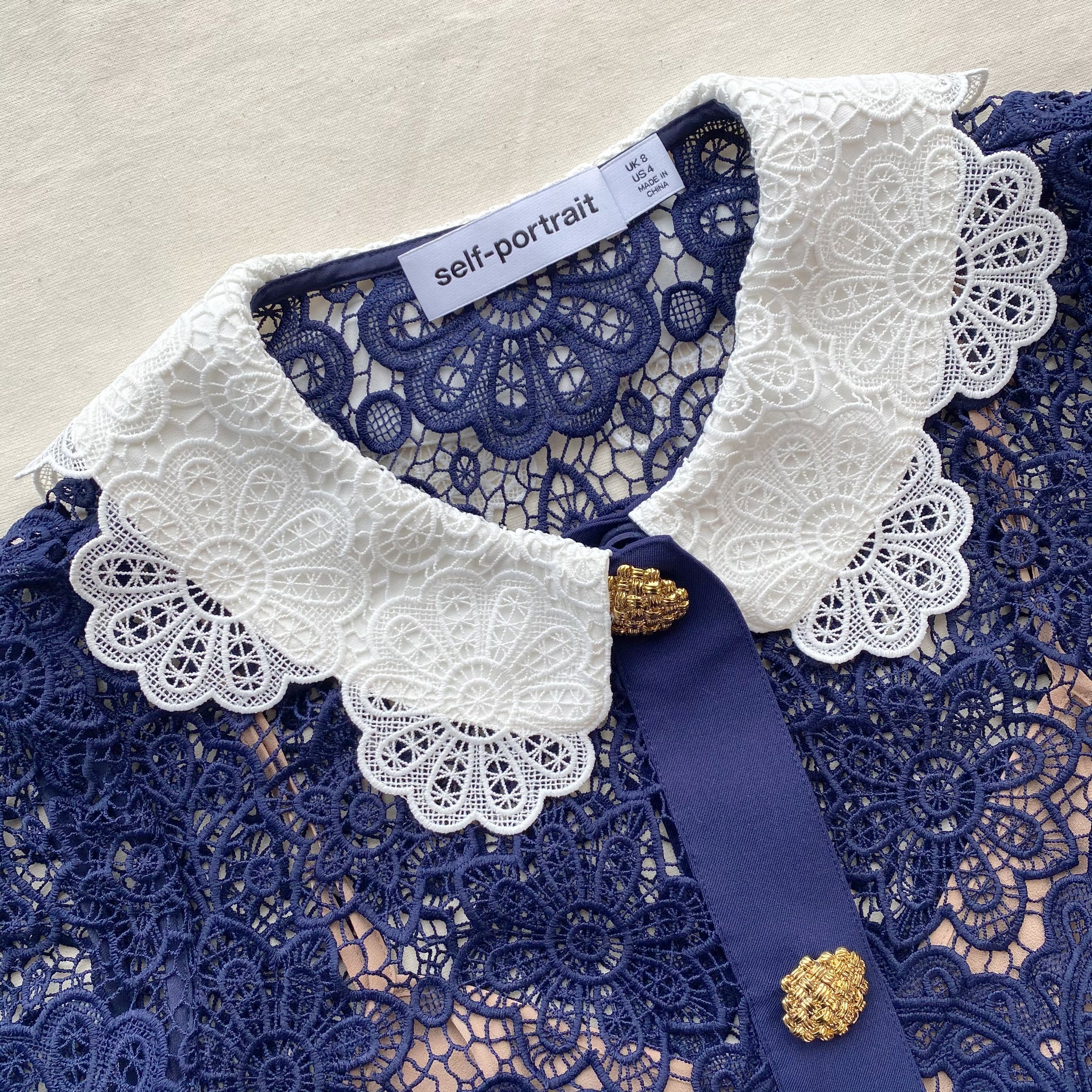 A close up of the fabric for the Navy Floral Guipure Midi Dress