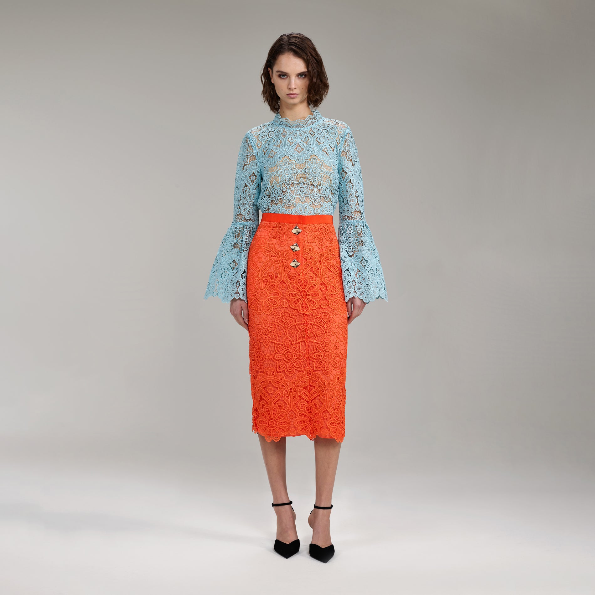 A woman wearing the Light Blue Floral Guipure Angel Sleeve Blouse