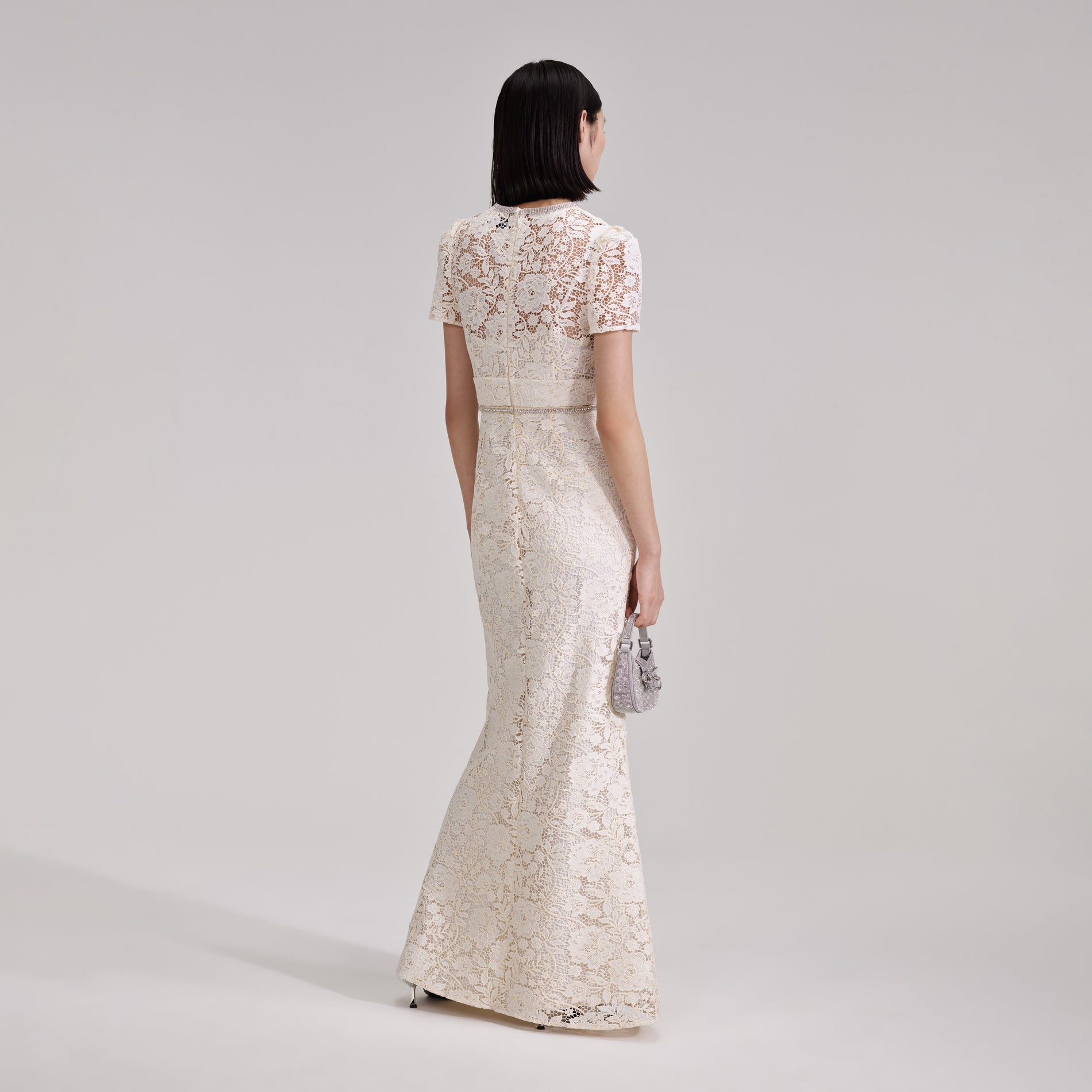 A woman wearing the Cream Cord Lace Bow Maxi Dress