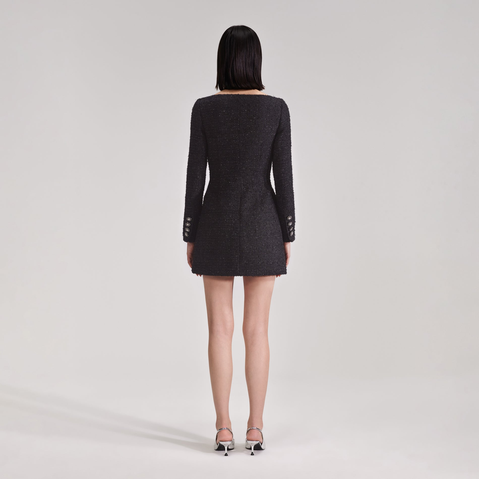 A woman wearing the Black Off Shoulder Boucle Mini Dress