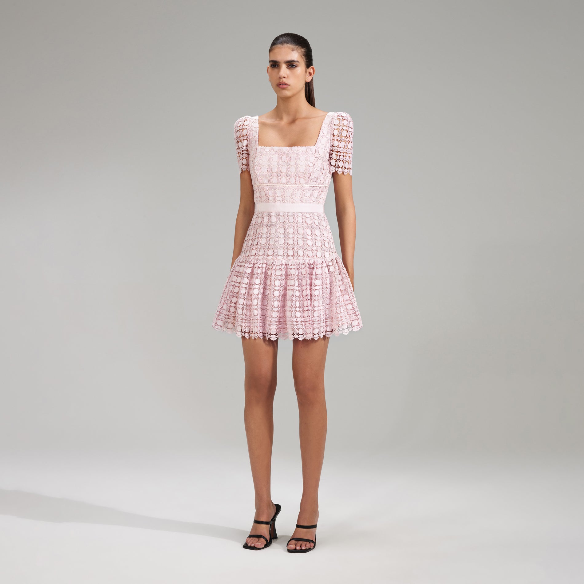 A woman wearing the Pink Petal Lace Mini Dress