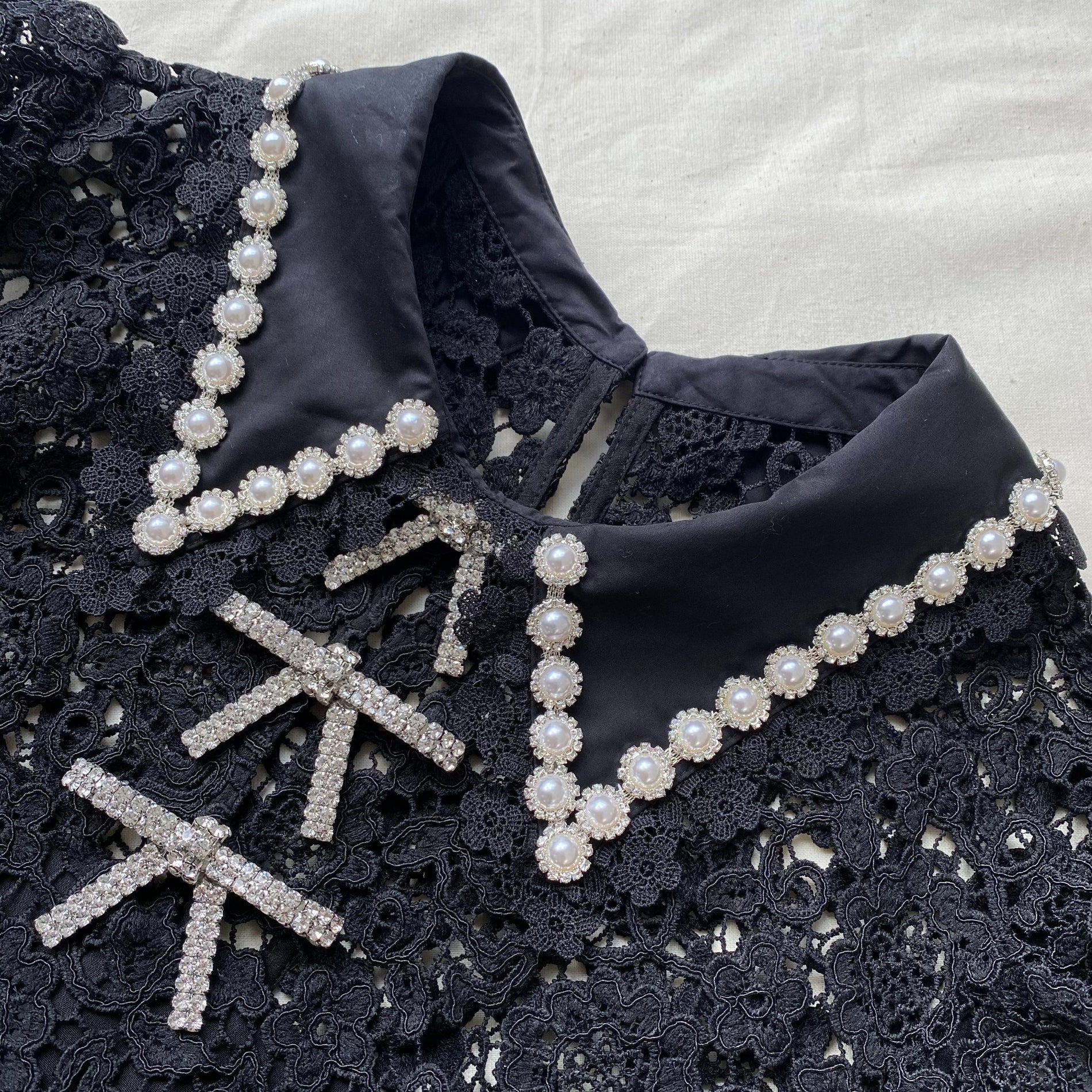 A close up of the fabric for the Black Guipure Mini Dress