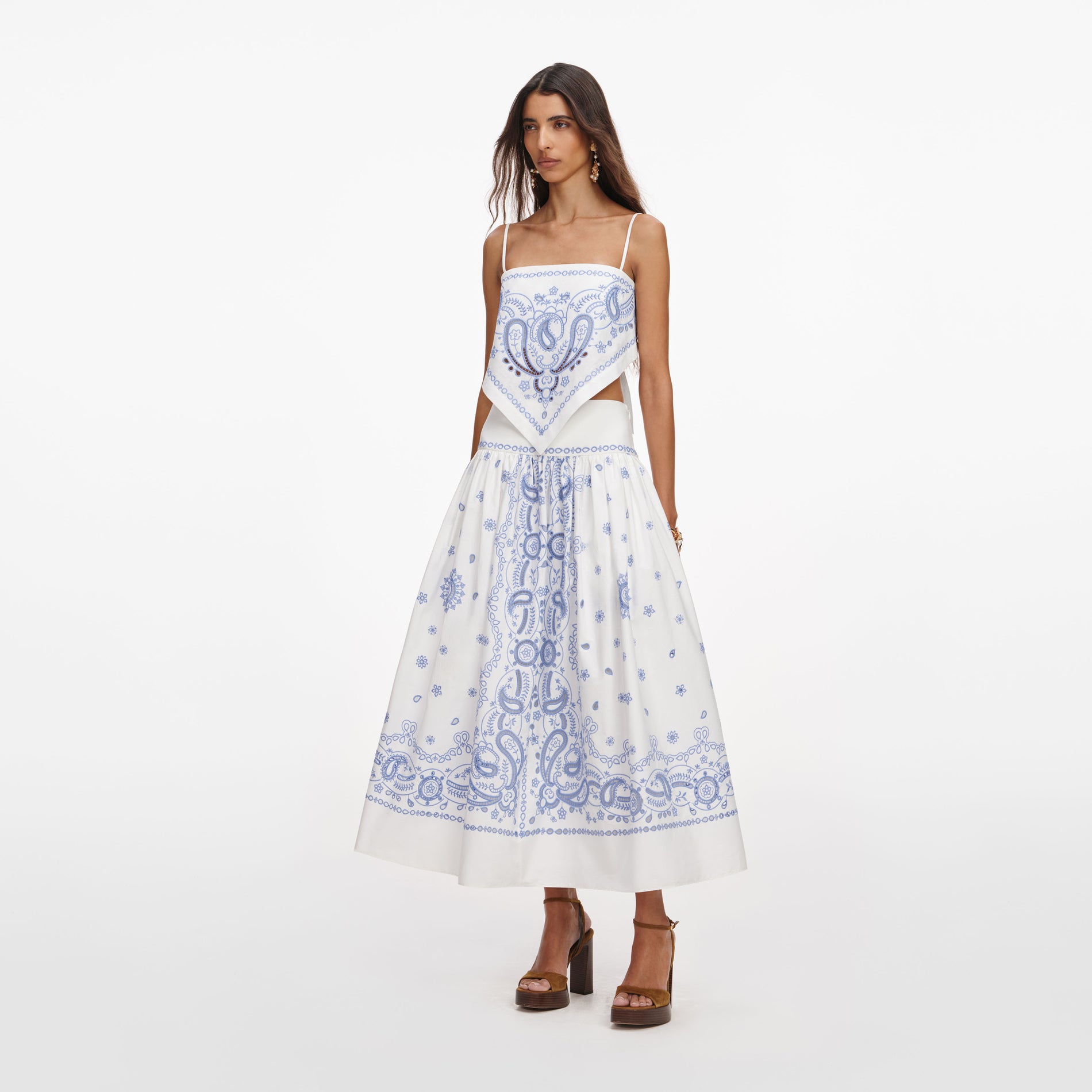 Side view of a woman wearing the White And Blue Embroidered Midi Skirt