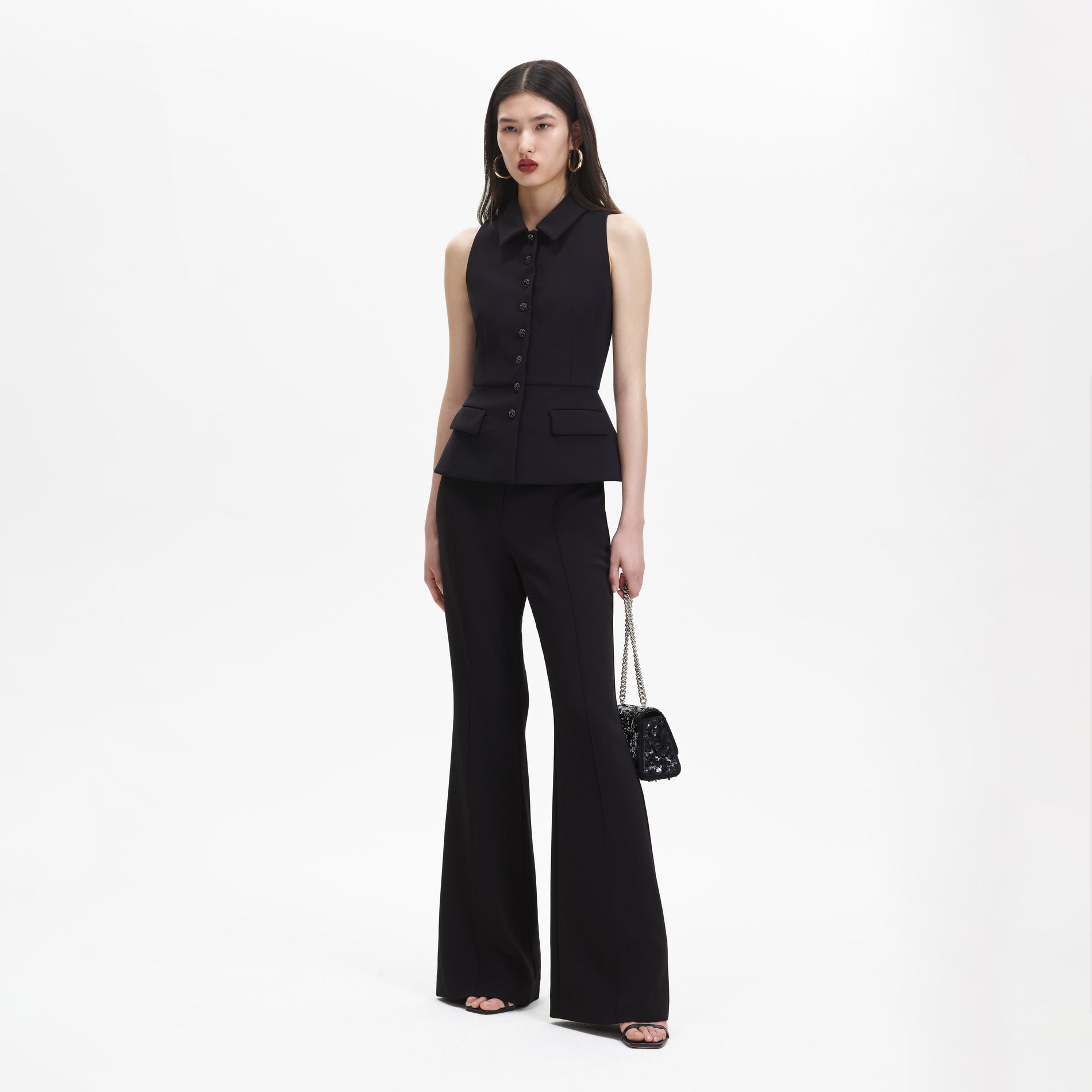 A woman wearing the Black Tailored Jumpsuit