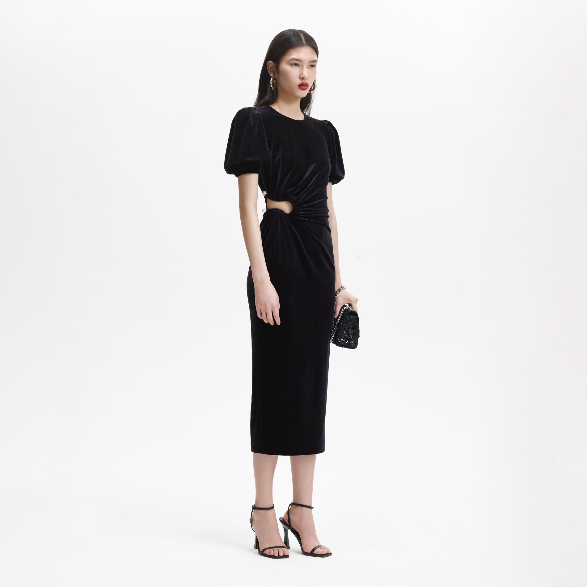 Side view of a woman wearing the Black Velvet Cut Out Midi Dress