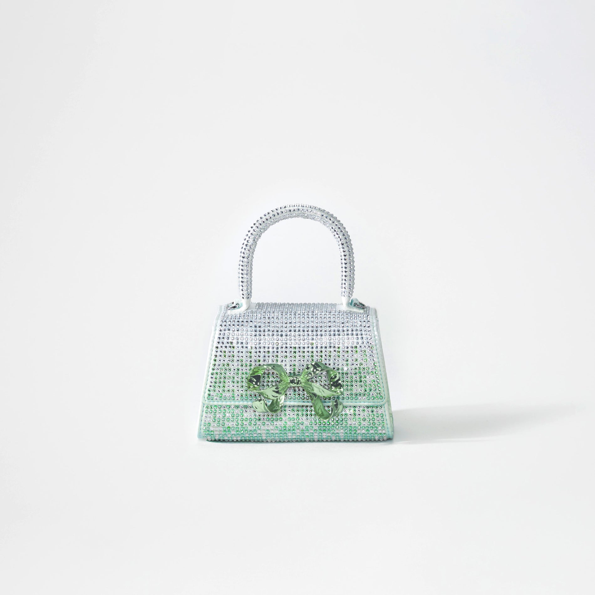 A woman wearing the Green Ombre Rhinestone Bow Micro Bag