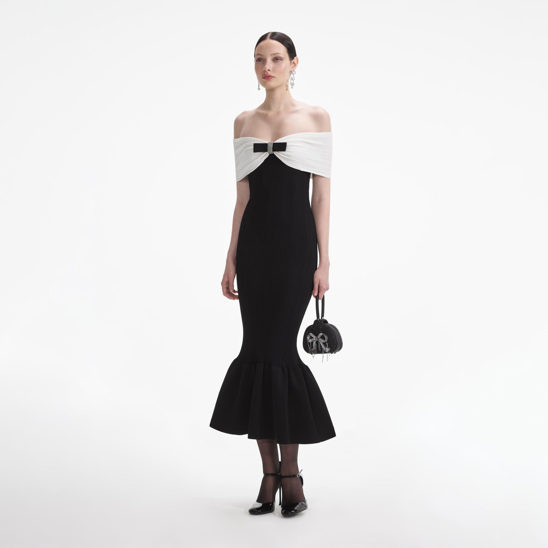 Side view of a woman wearing the Black Knit Bow Midi Dress