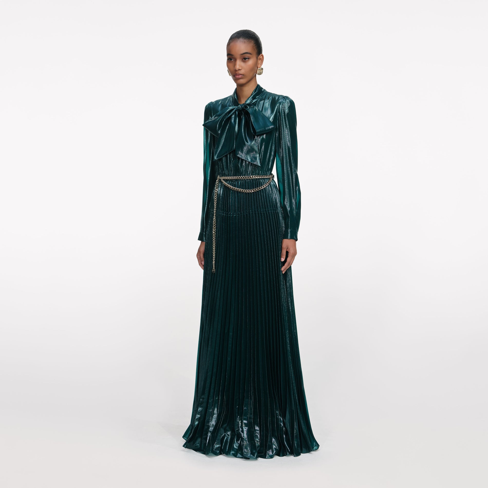 Side view of a woman wearing the Green Metallic Pussy Bow Maxi Dress