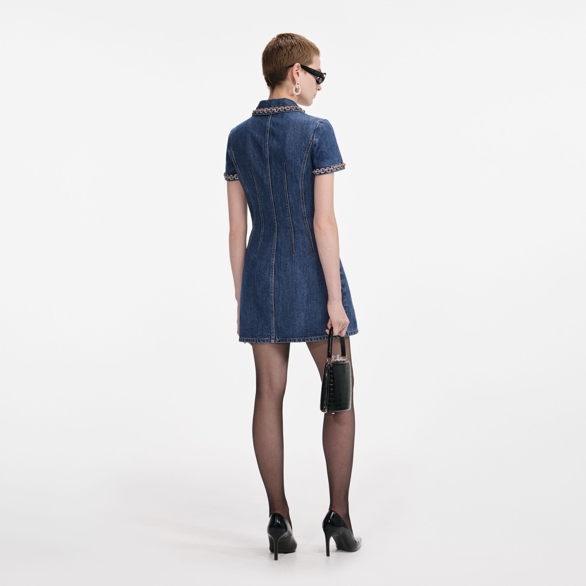 Back view of a woman wearing the Denim Crystal Trim Collared Mini Dress