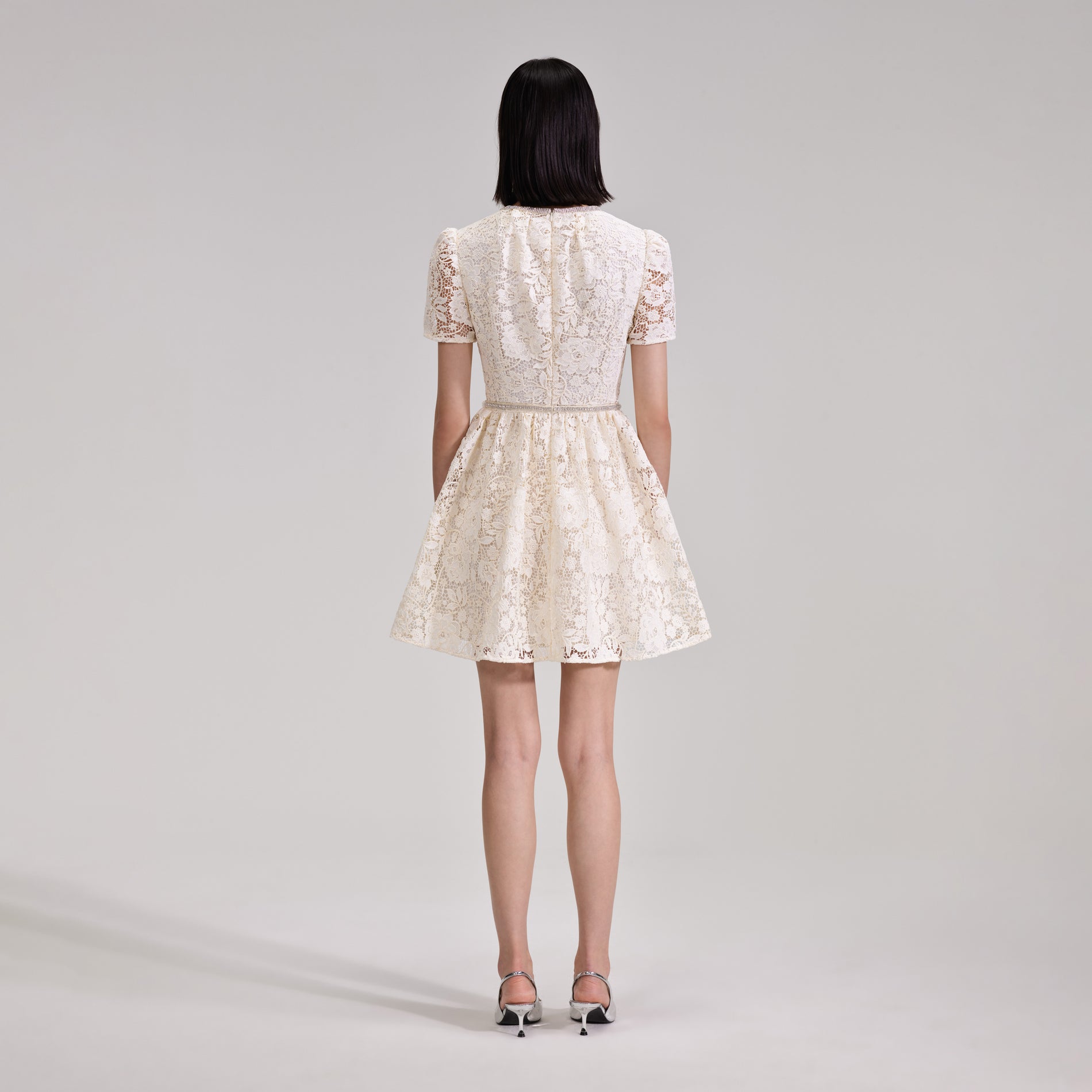 A woman wearing the Cream Cord Lace Bow Mini Dress