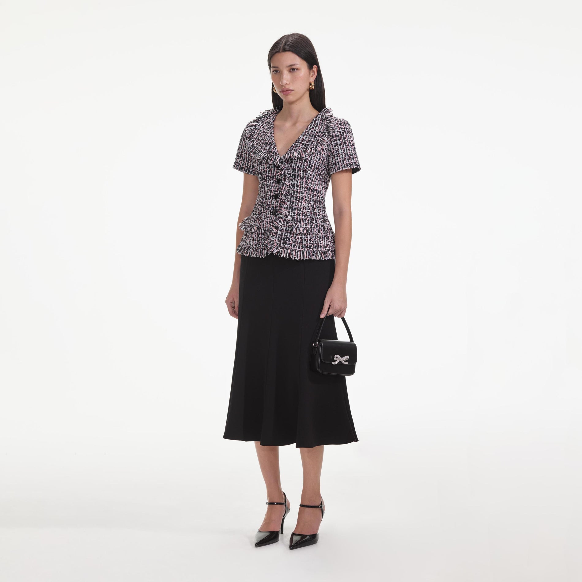 Side view of a woman wearing the Black Boucle Fringed Midi Dress