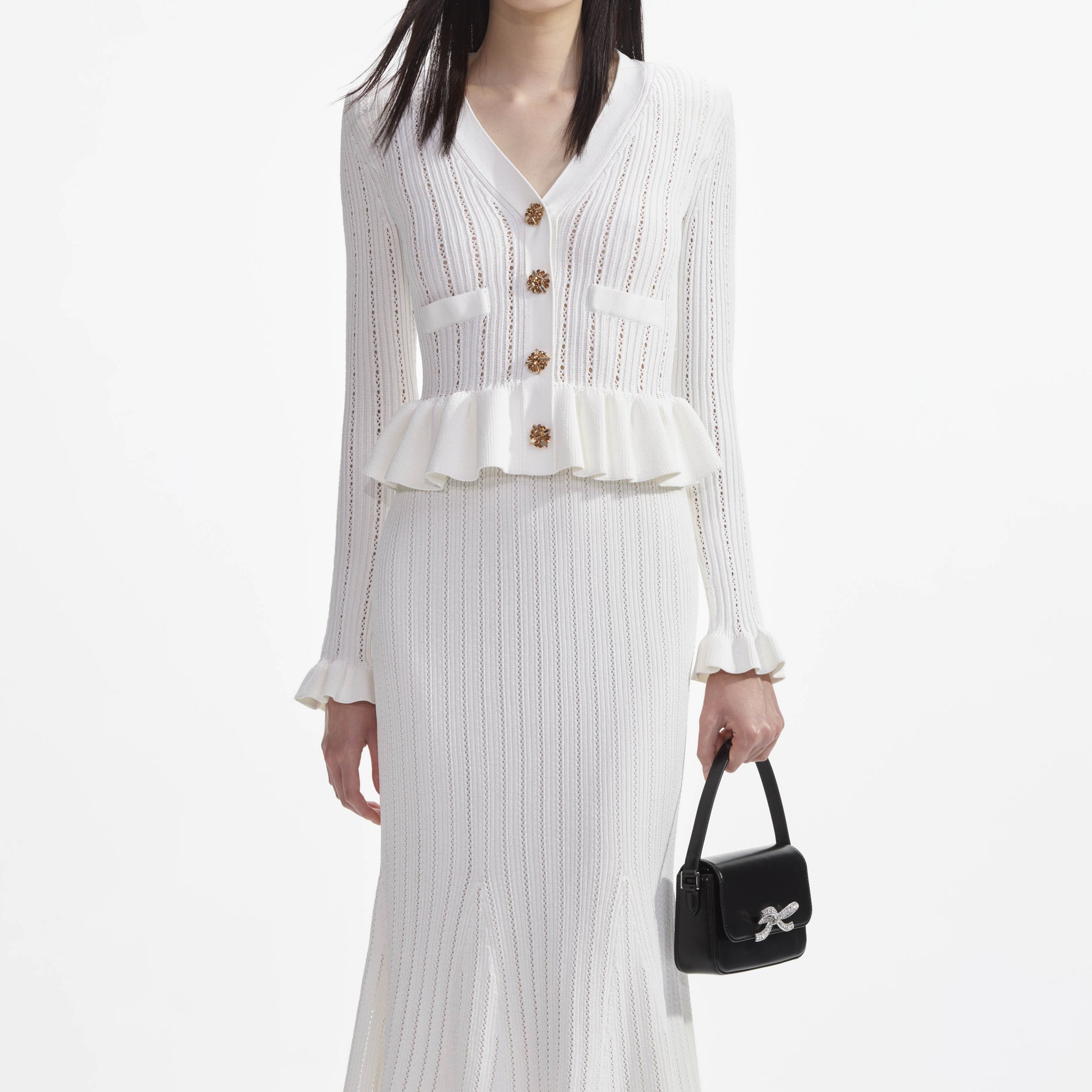 A close up of a woman wearing the White Knit Peplum Midi Dress
